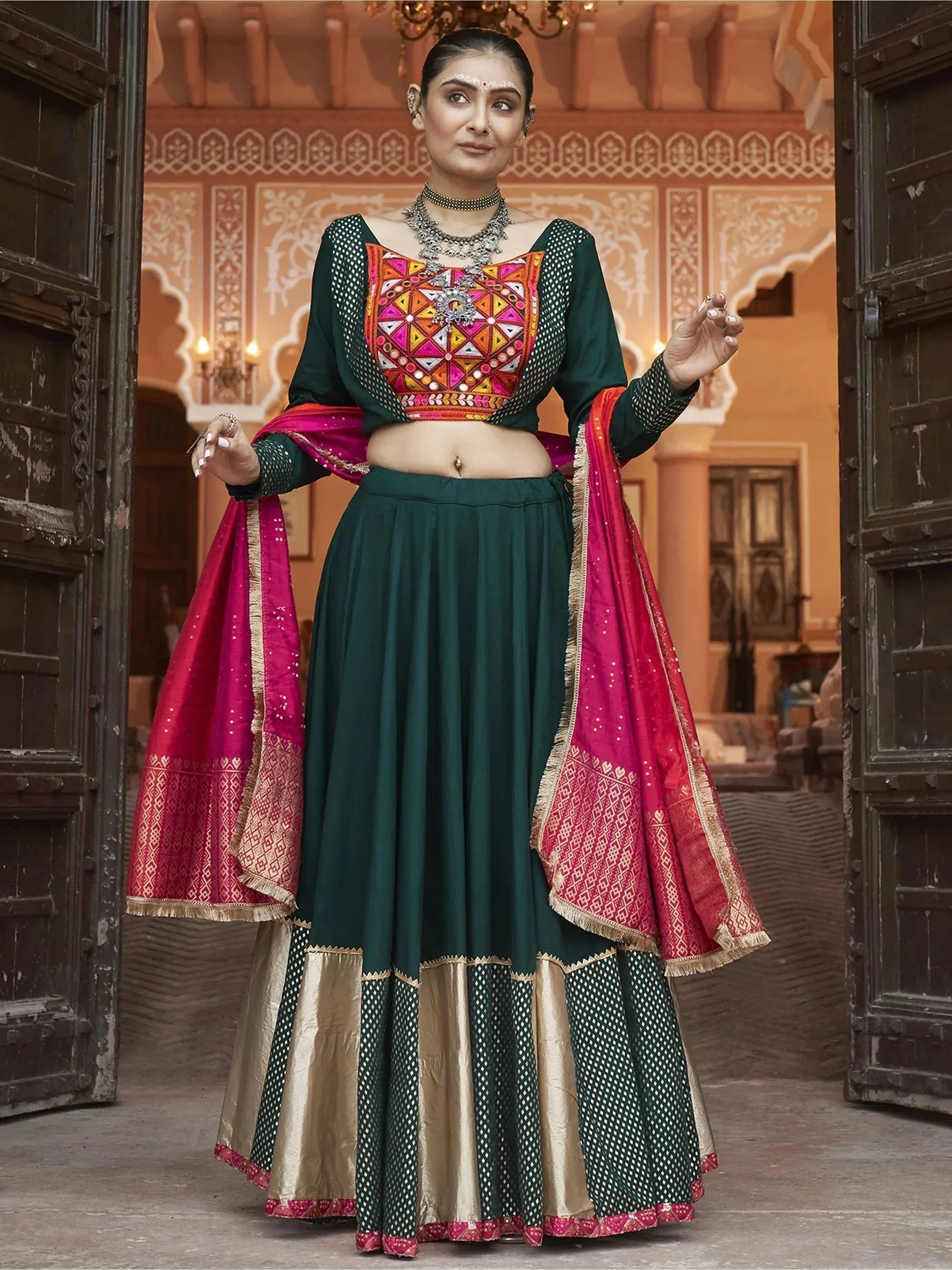 Green and pink embroidered lehenga choli with mirror work, perfect for Indian ethnic wear occasions.
