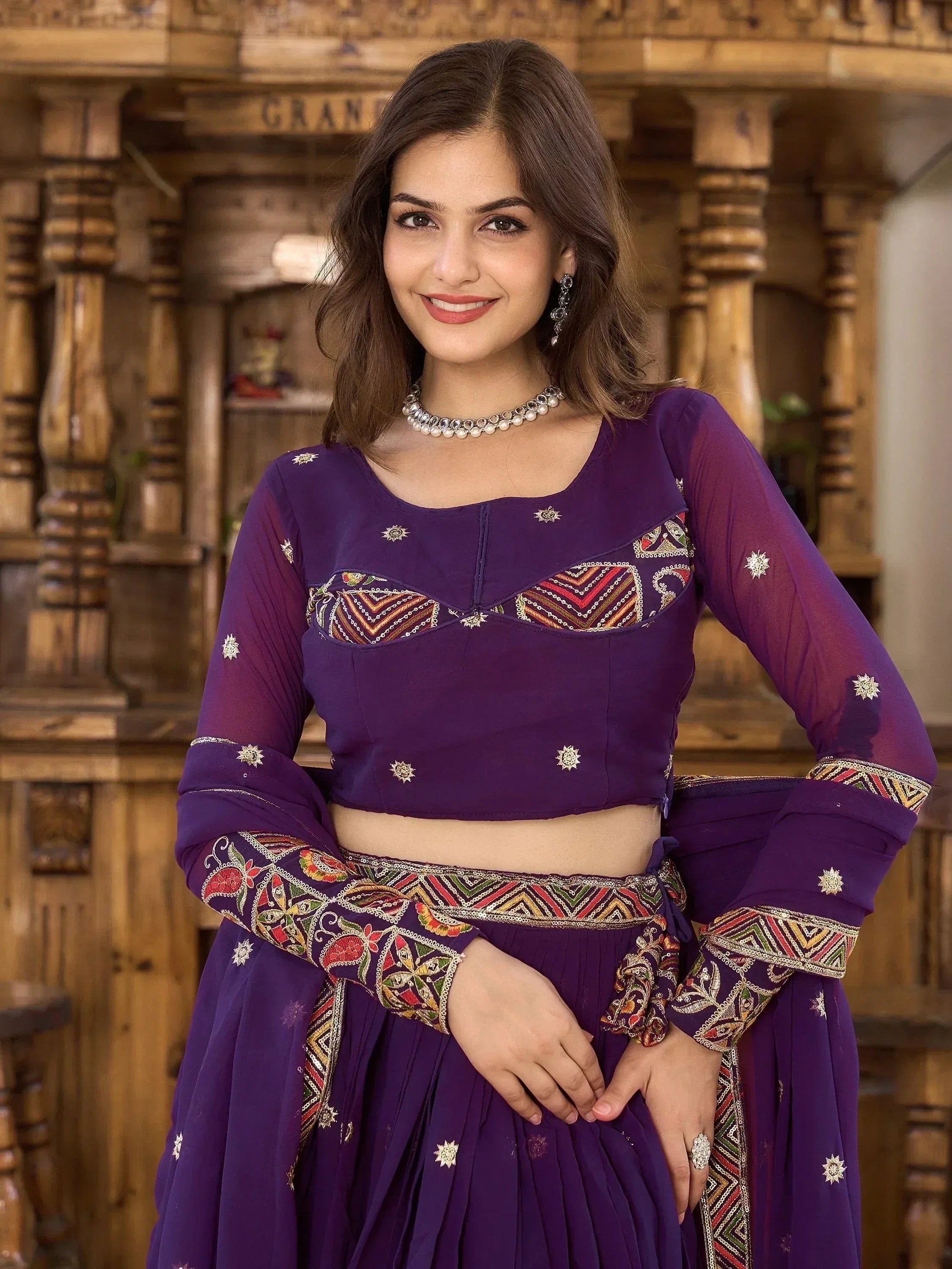 Purple embroidered lehenga choli with sheer sleeves and traditional jewelry, perfect for Indian ethnic wear