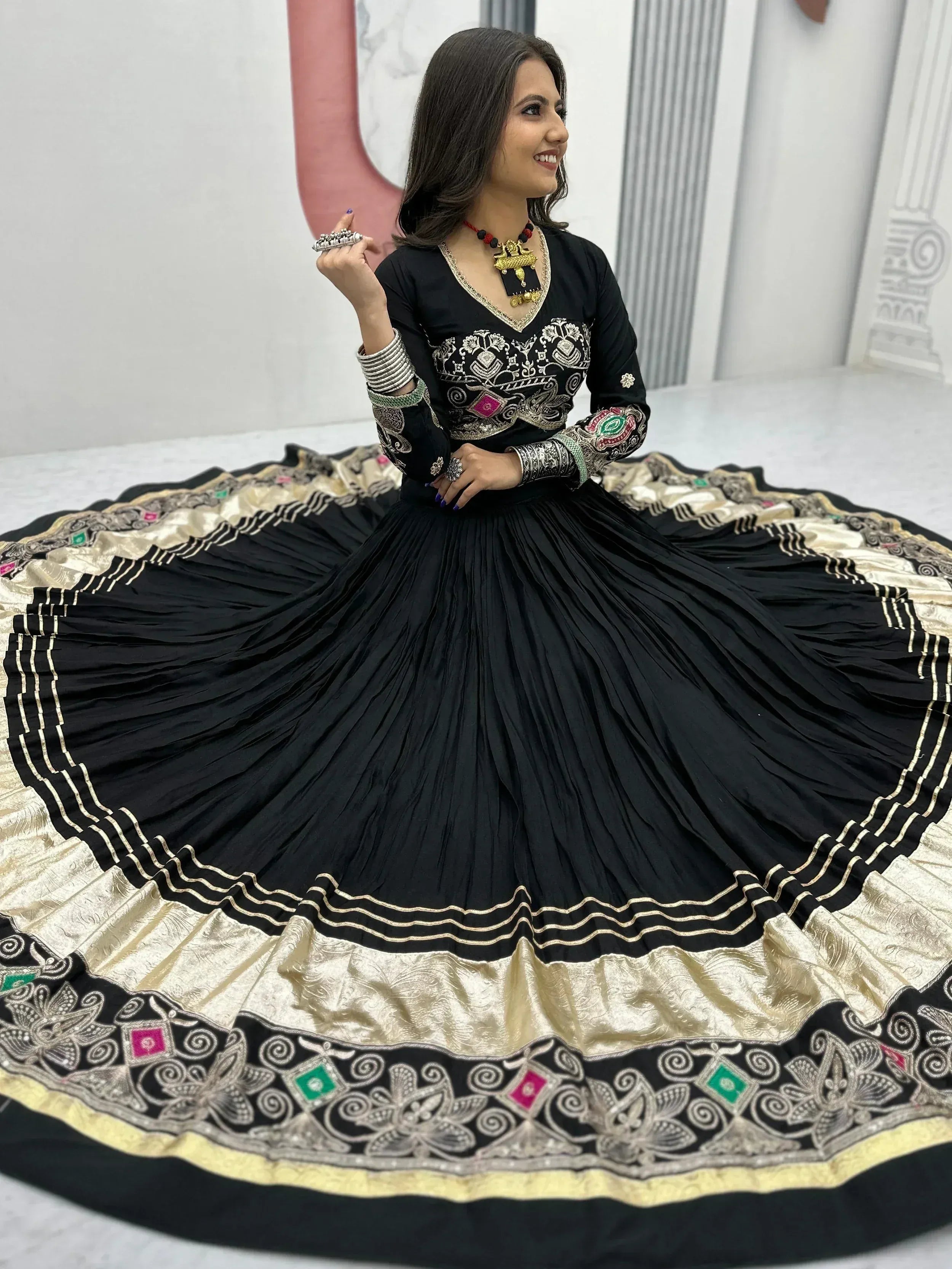 Black embroidered lehenga choli with gold border, perfect for Indian ethnic wear and festive occasions.