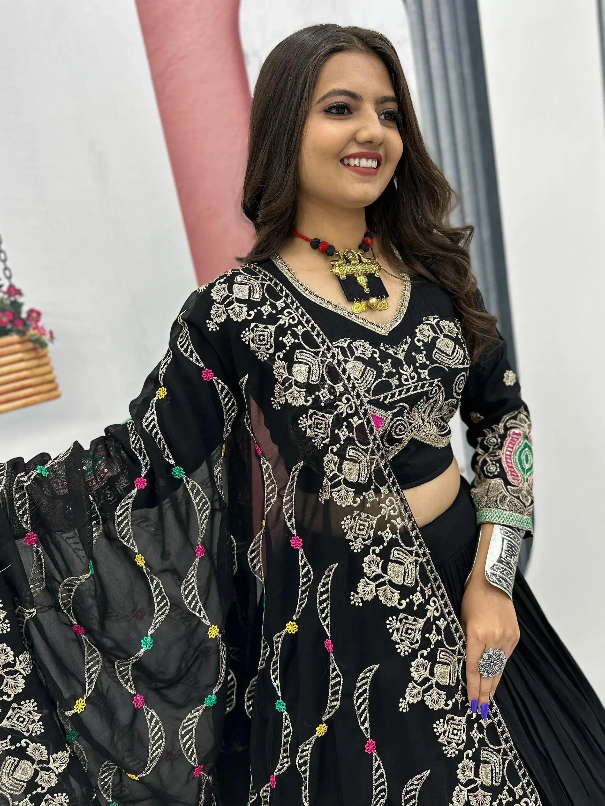 Black embroidered lehenga choli with colorful floral details and gold thread work, perfect for Indian ethnic wear.