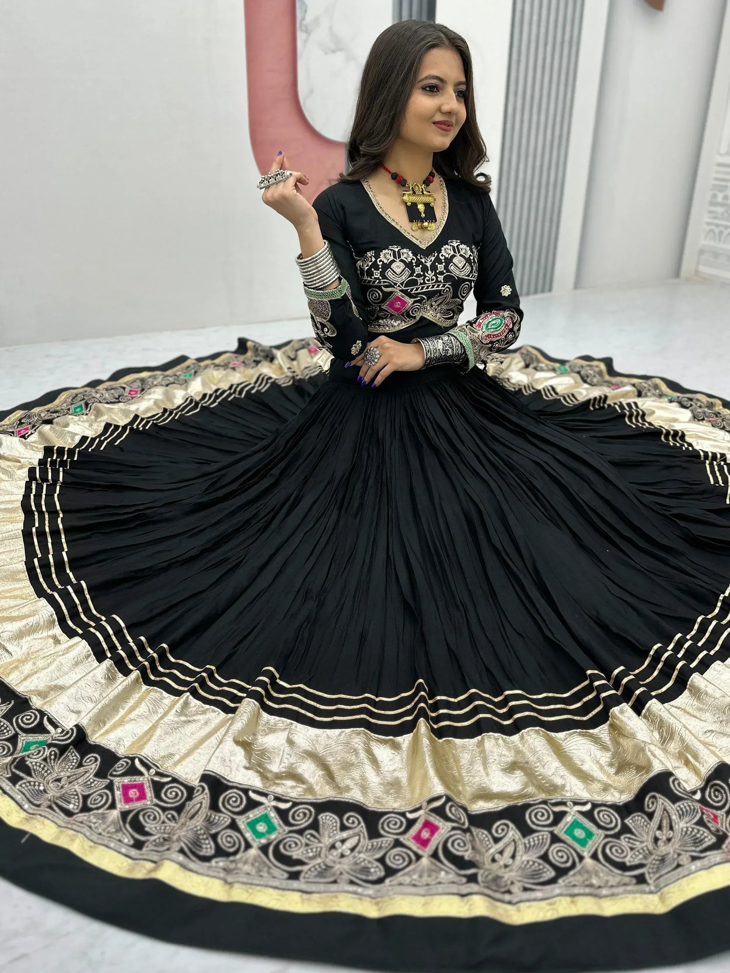 Black embroidered ethnic gown with gold border, perfect for Indian occasions and festive wear.