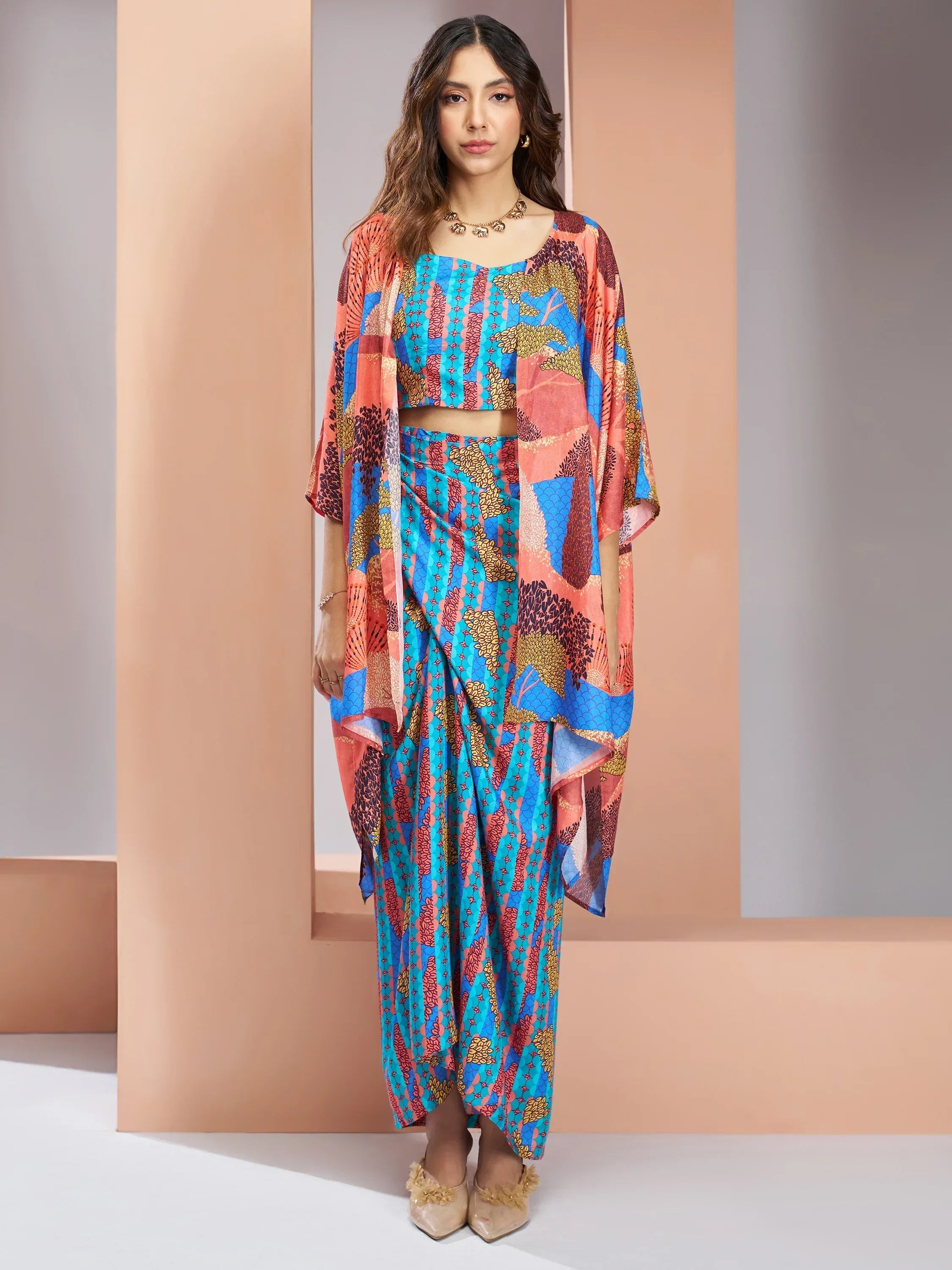 Woman wearing vibrant printed Indo-western saree set in blue and coral with draped silhouette