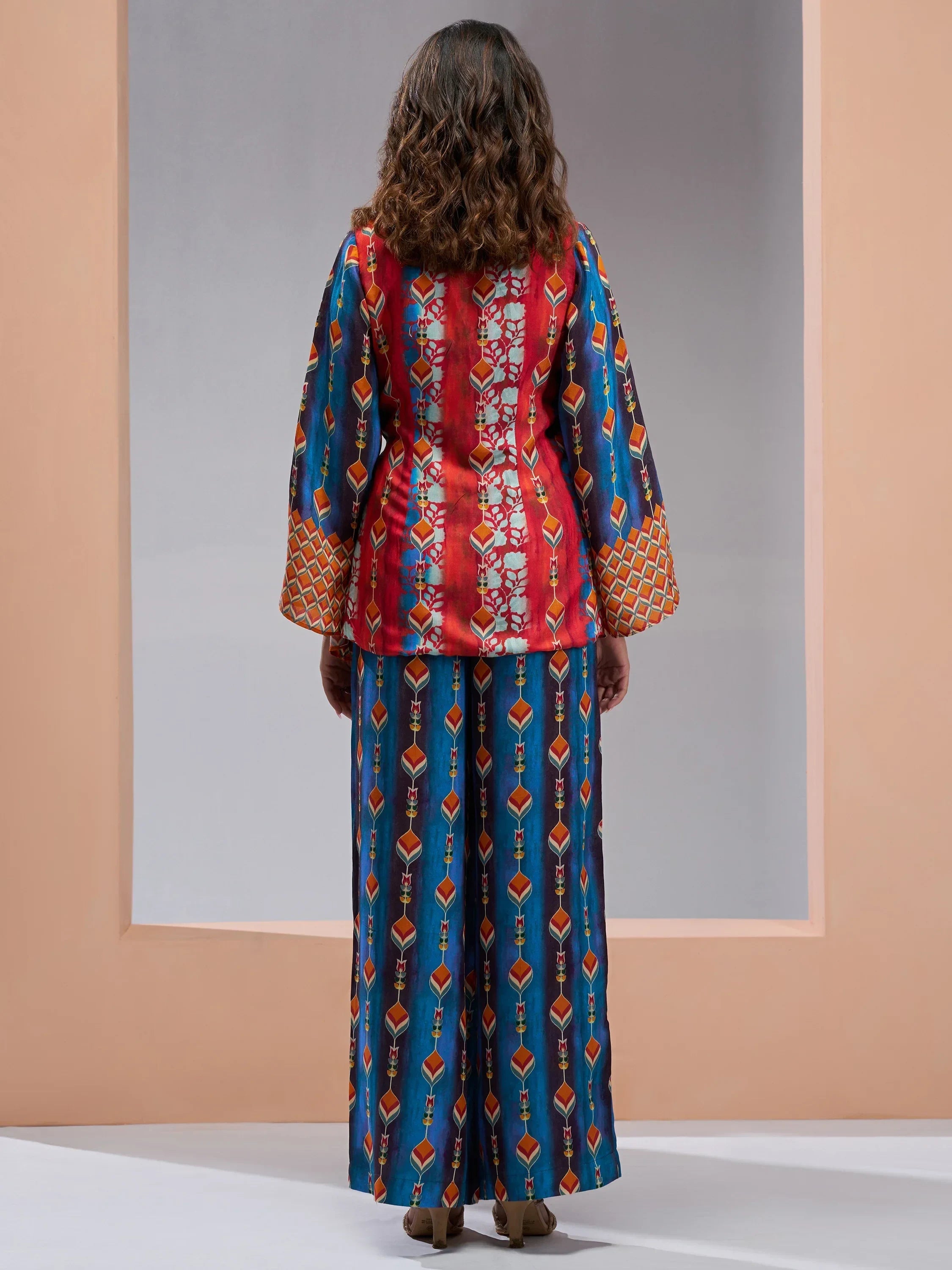 Woman wearing colorful printed ethnic kurta and wide-leg pants, back view