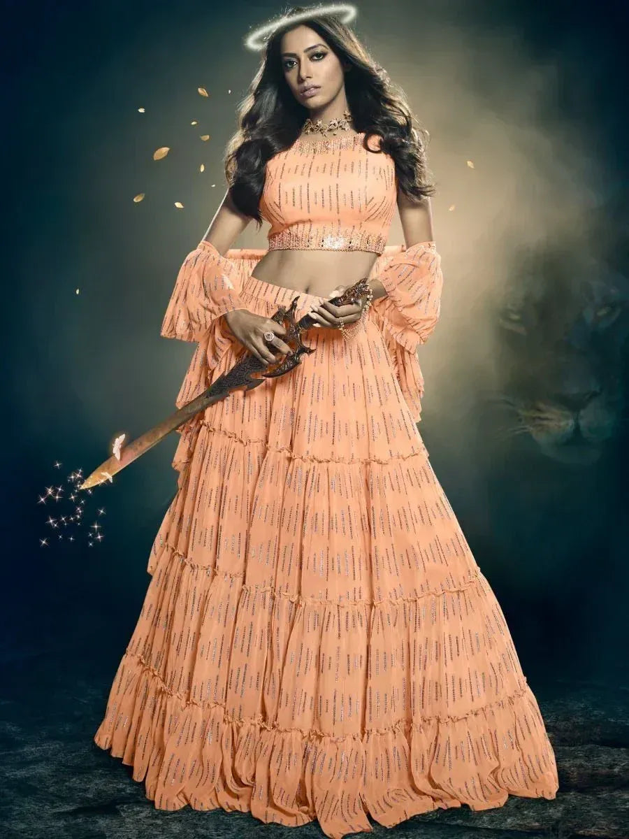 Peach designer lehenga choli with ruffled sleeves, sequin work, and dramatic sword pose for festive occasions