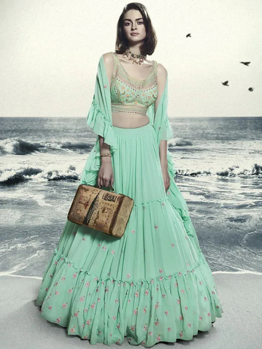 Mint green embroidered lehenga choli with floral details, beach backdrop, perfect for ethnic occasions