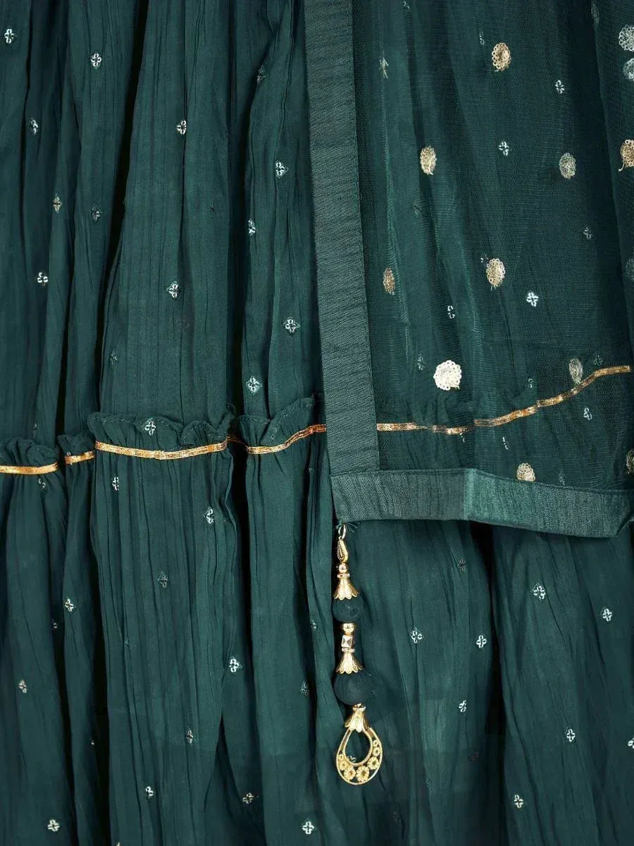 Emerald green ethnic gown with gold embroidery and tassel detailing, perfect for Indian occasions.