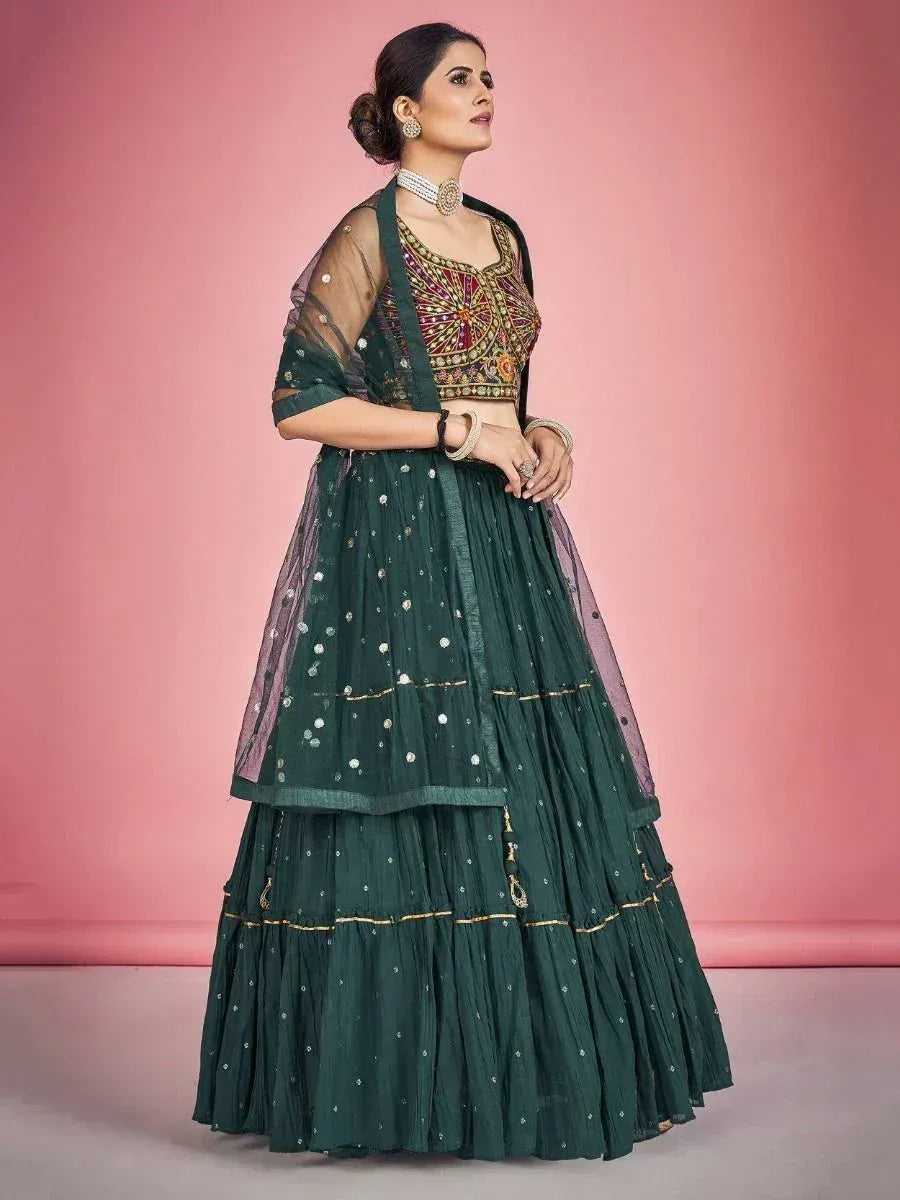 Emerald green designer lehenga choli with intricate embroidery and sheer dupatta, perfect for Indian ethnic occasions.
