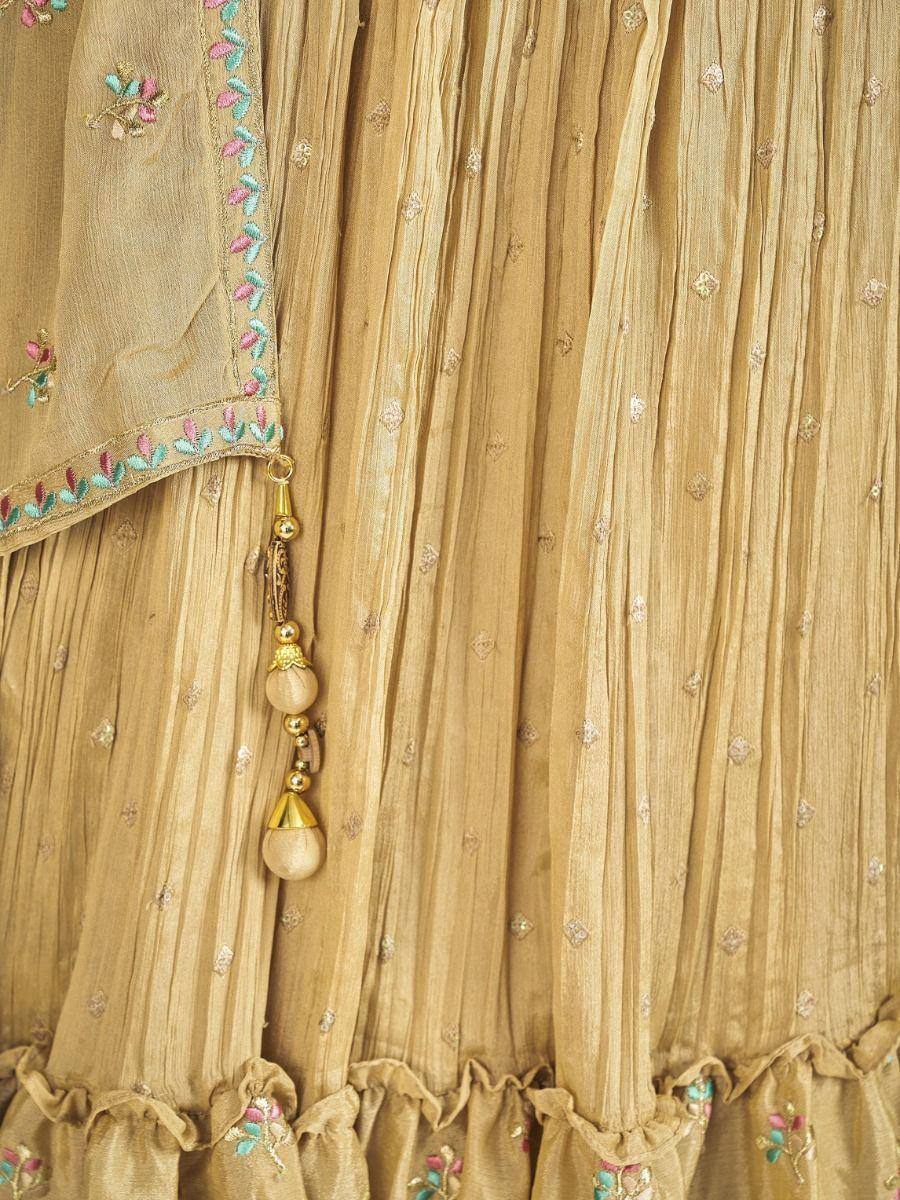 Beige embroidered lehenga with floral detailing and gold tassels, perfect for ethnic occasions