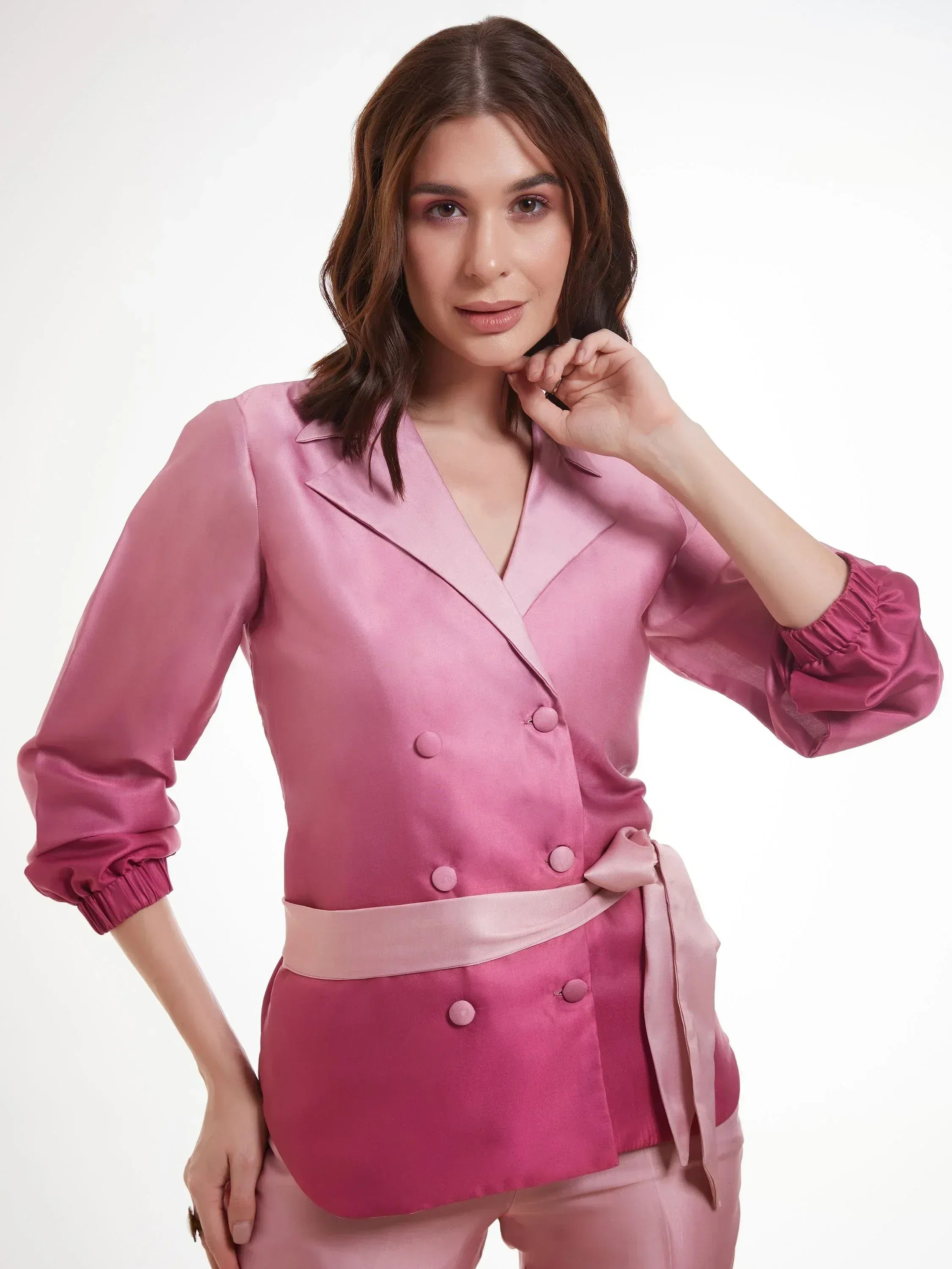 Woman wearing a stylish pink satin double-breasted blazer with fabric belt
