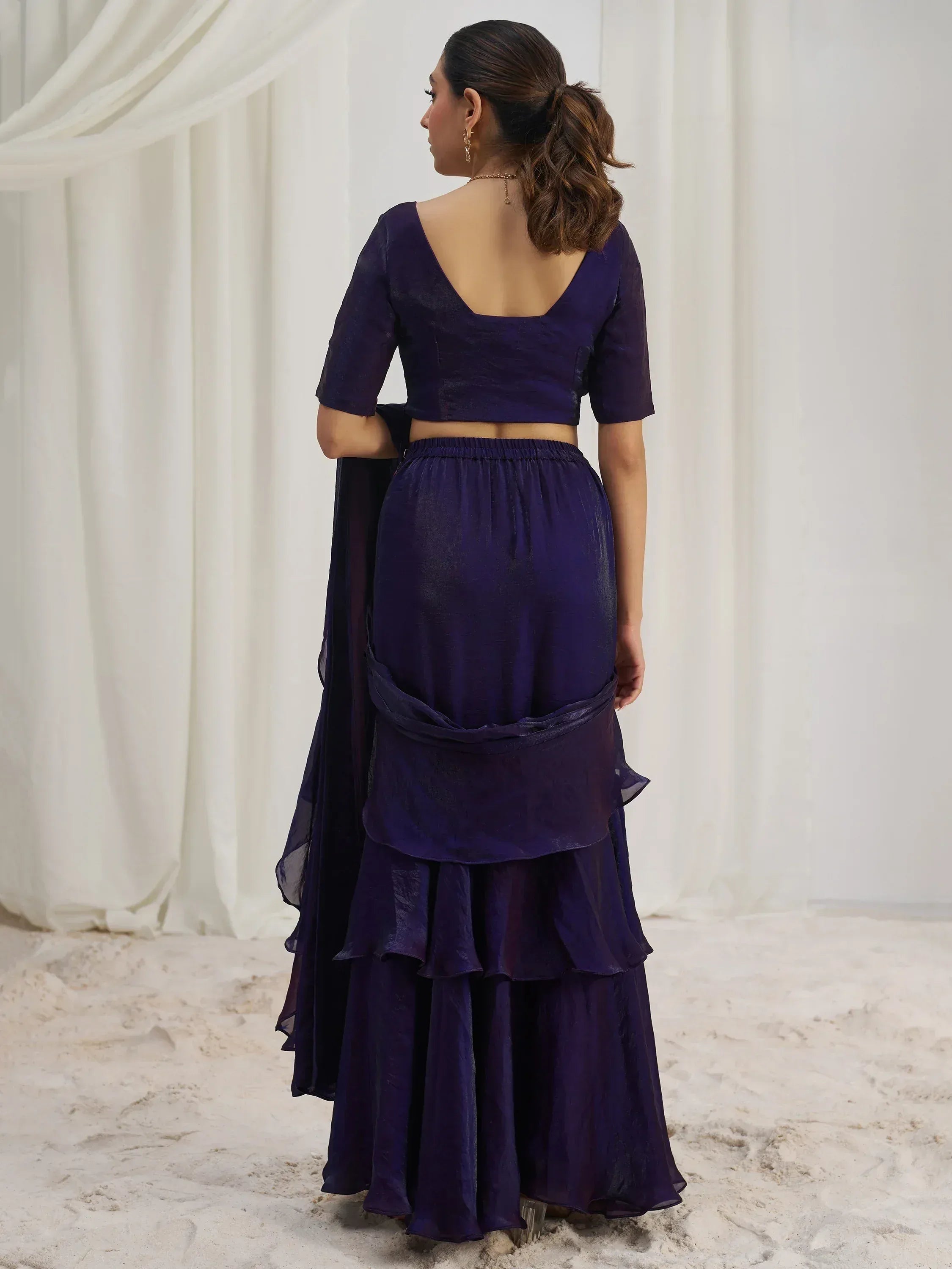 Elegant purple ethnic gown with ruffled layers and backless design, perfect for Indian occasions