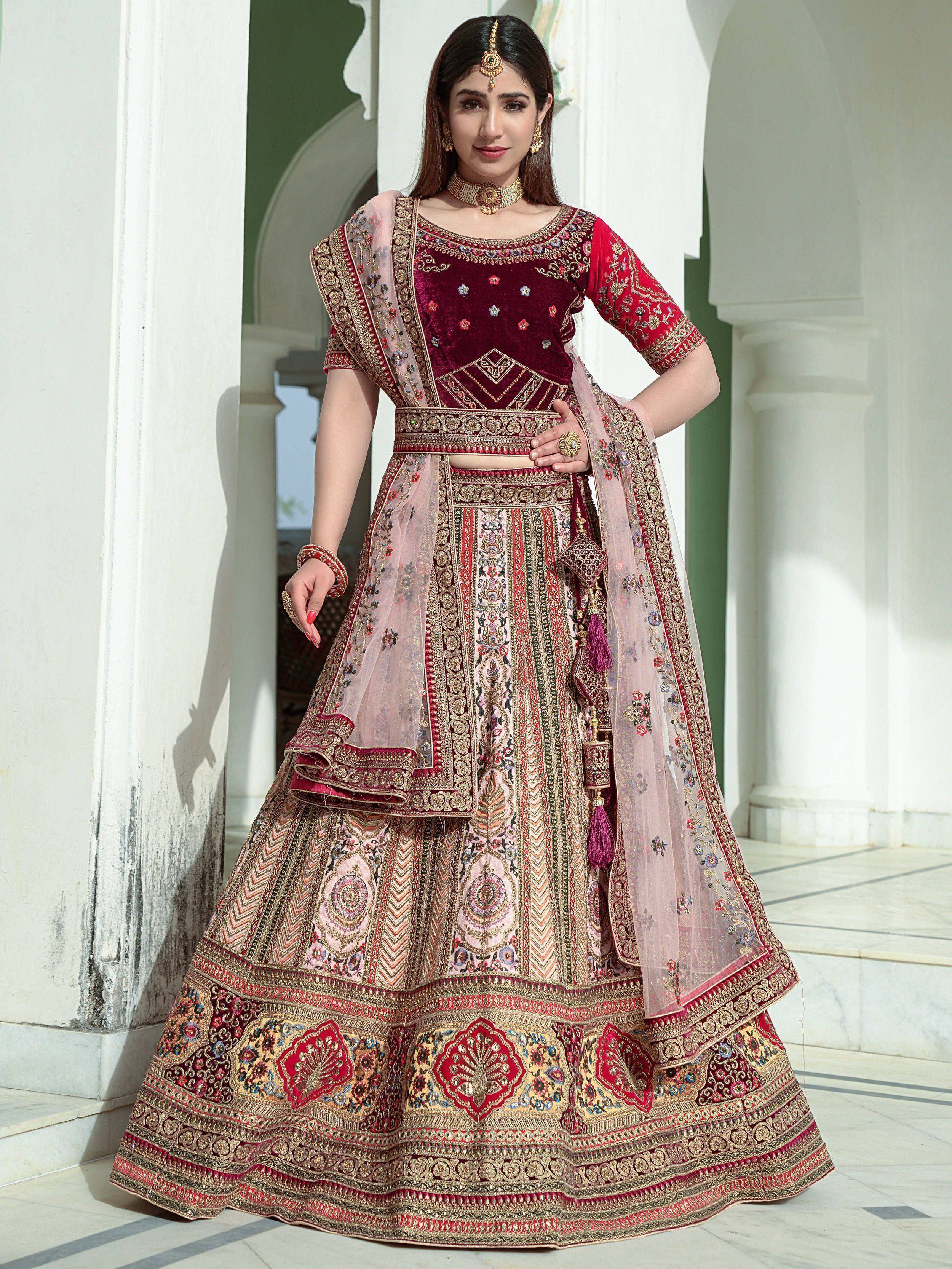 Designer maroon velvet lehenga choli with heavy embroidery and net dupatta, perfect for Indian weddings and festive occasions.