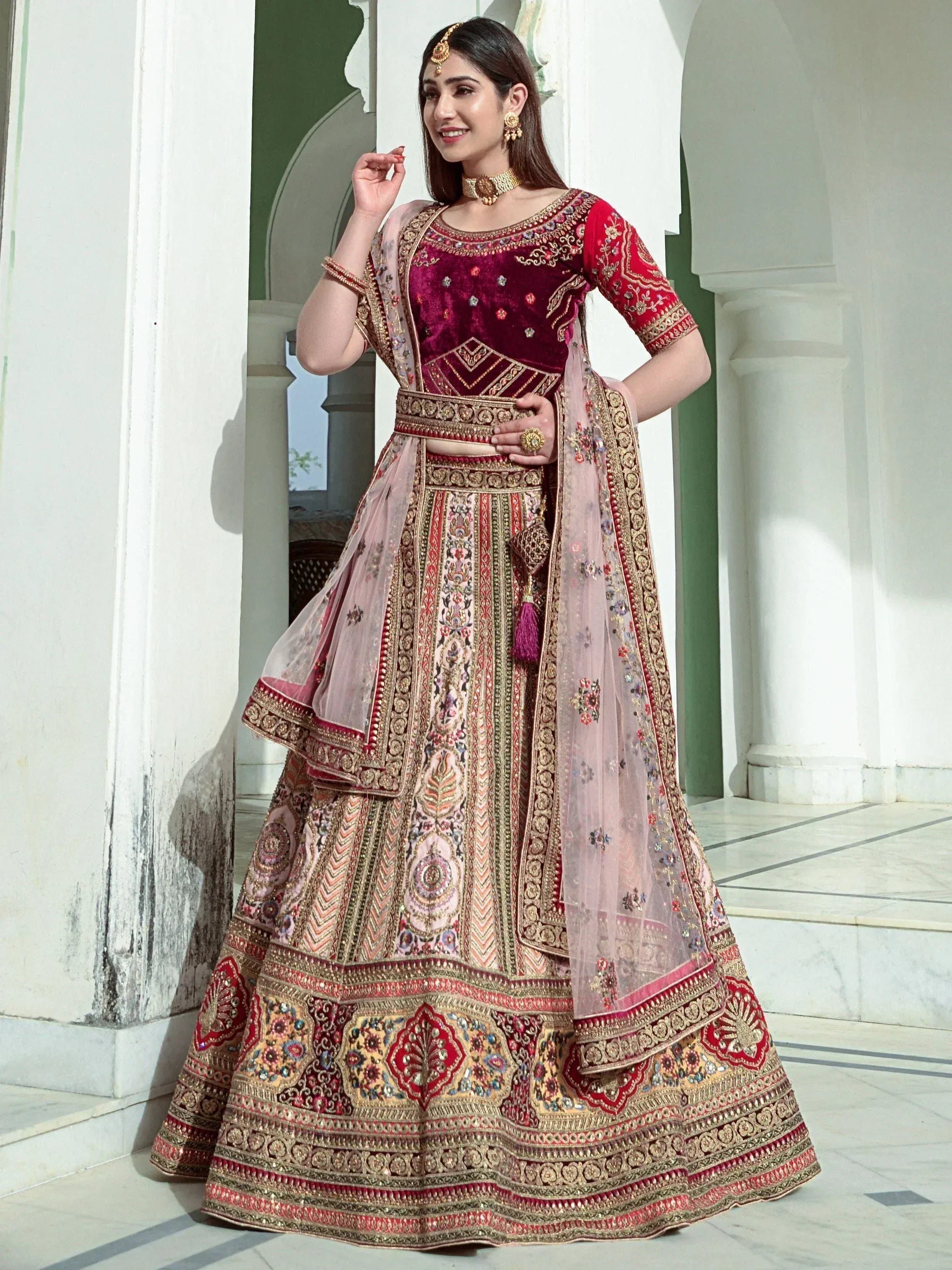 Elegant maroon velvet lehenga choli with gold embroidery, perfect for Indian weddings and festive occasions.