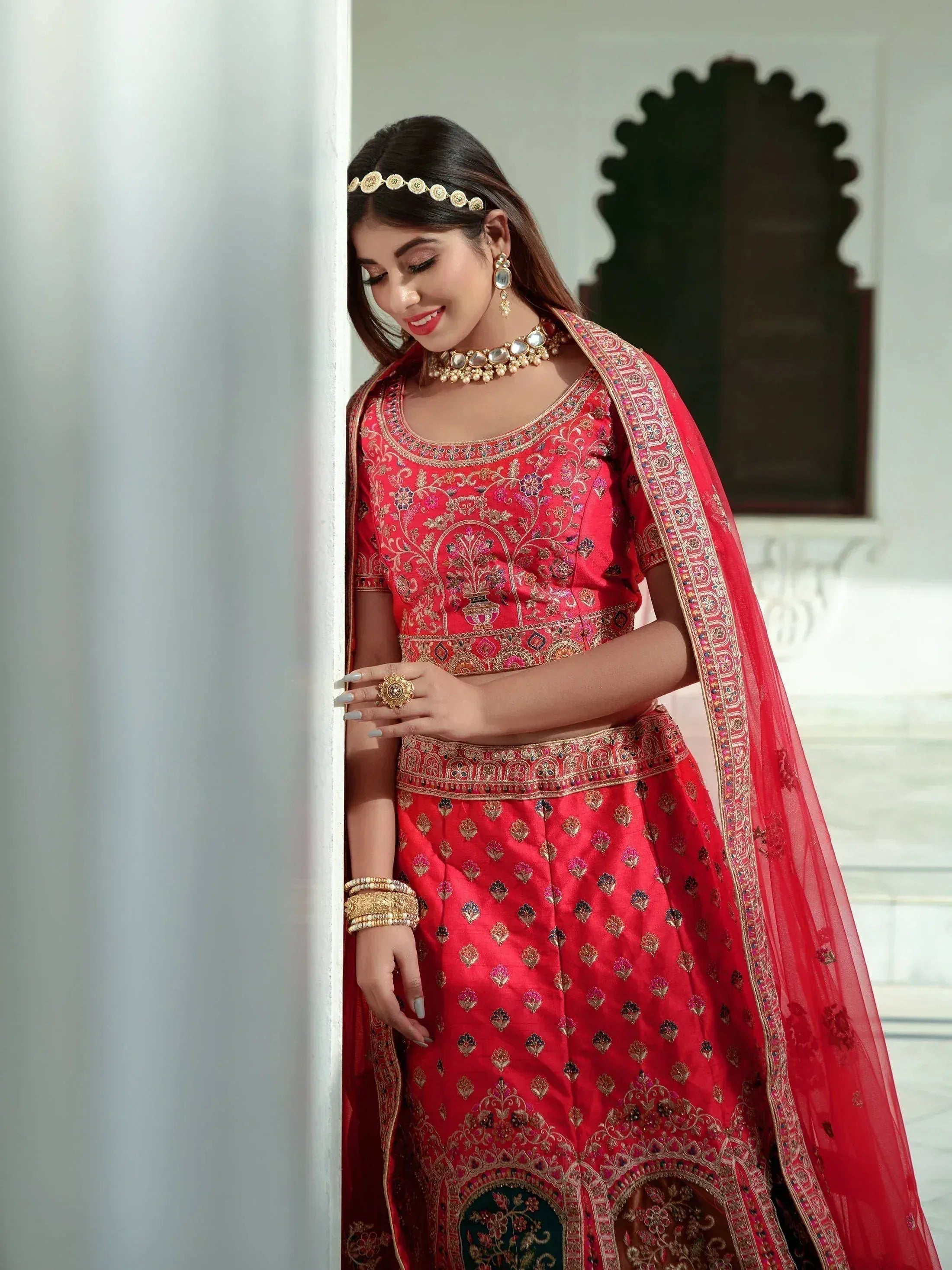 Red embroidered lehenga choli with gold detailing, perfect for Indian weddings and festive occasions.