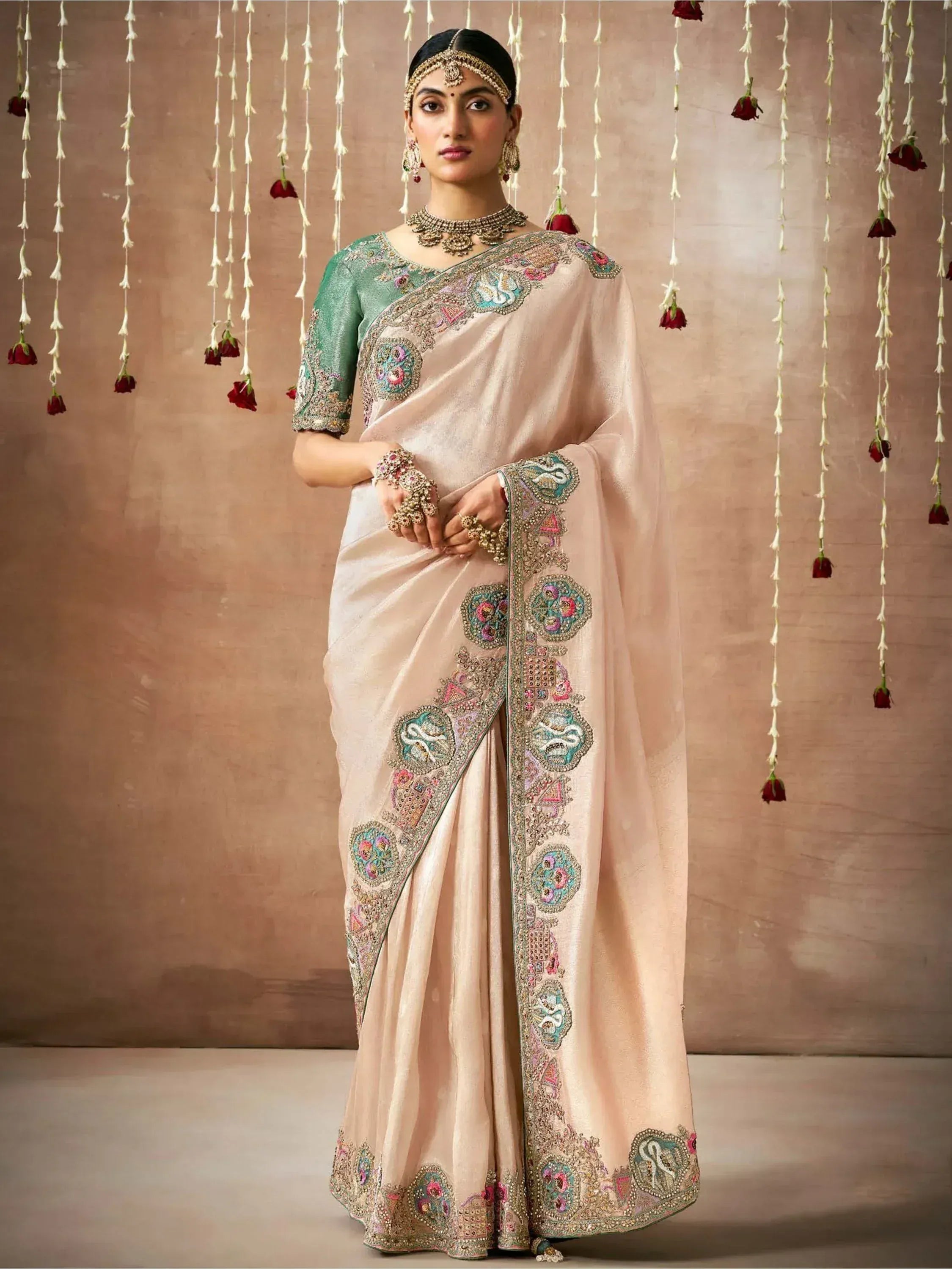 Elegant beige saree with intricate floral embroidery and green blouse, perfect for Indian ethnic occasions.