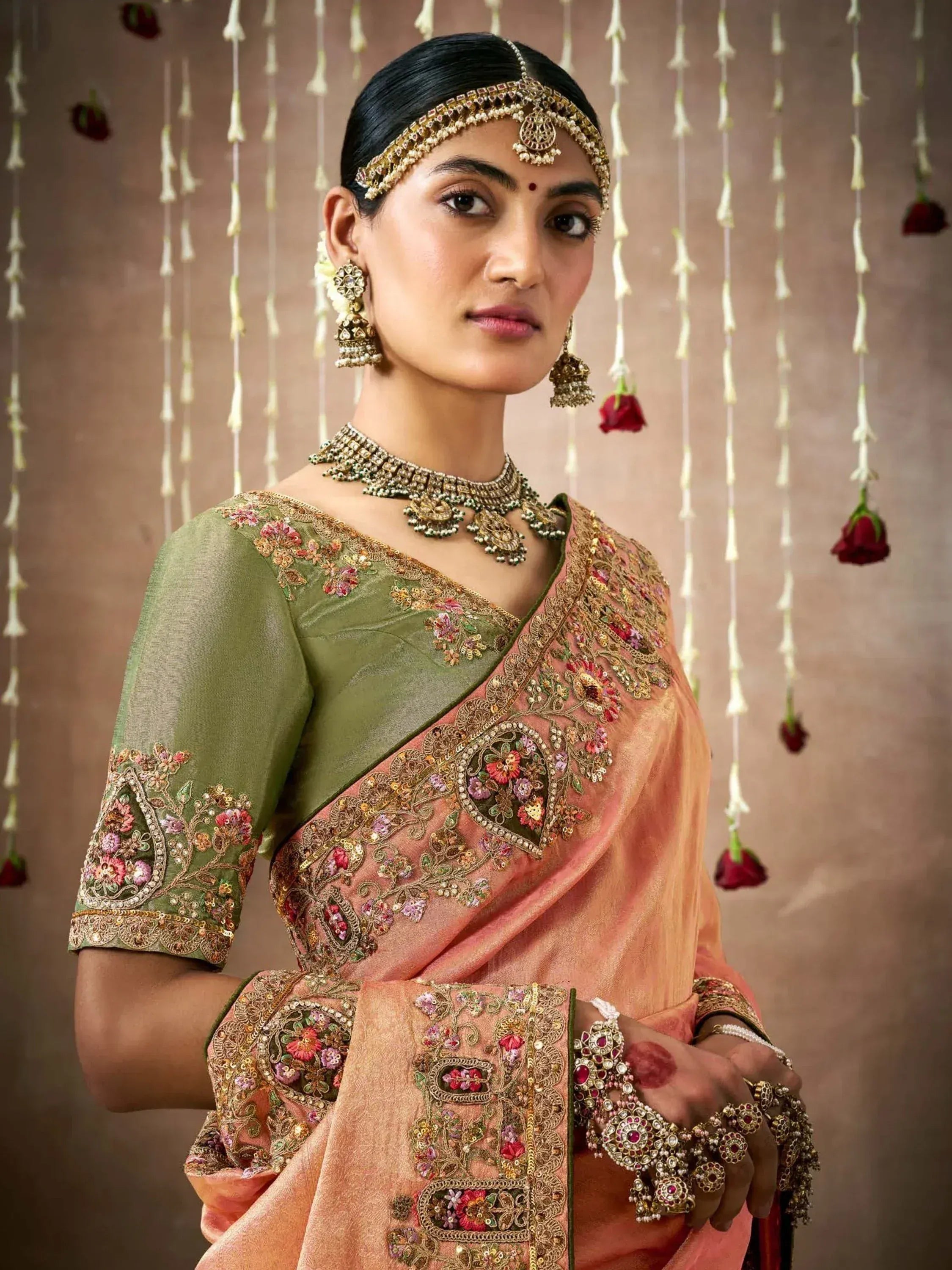 Elegant Indian saree with floral embroidery, gold jewelry, and traditional bridal accessories for festive occasions.