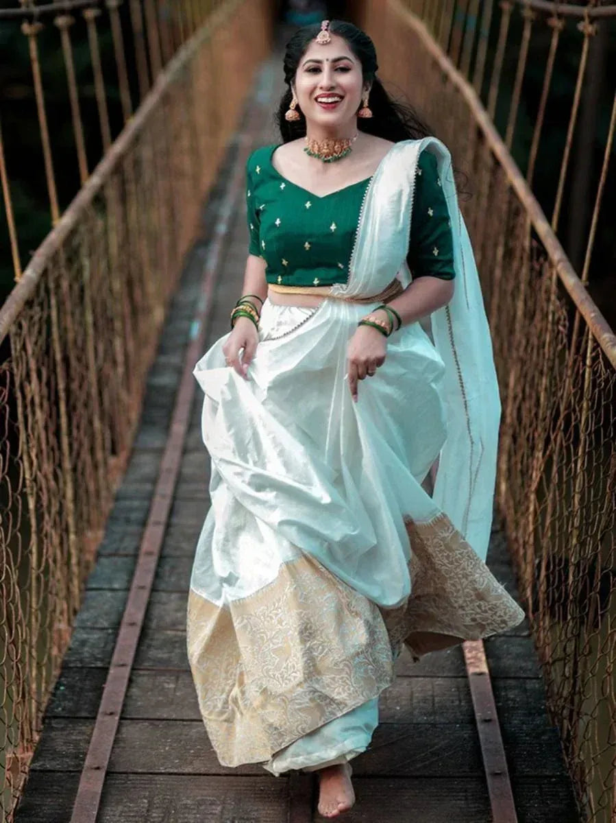 Woman in green embroidered blouse and white-gold lehenga walking on bridge, Indian ethnic wear
