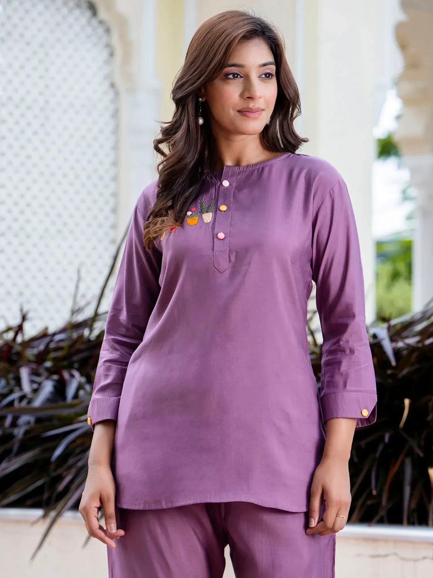 Purple embroidered kurta with matching pants, featuring floral appliqué and colorful buttons for ethnic wear.