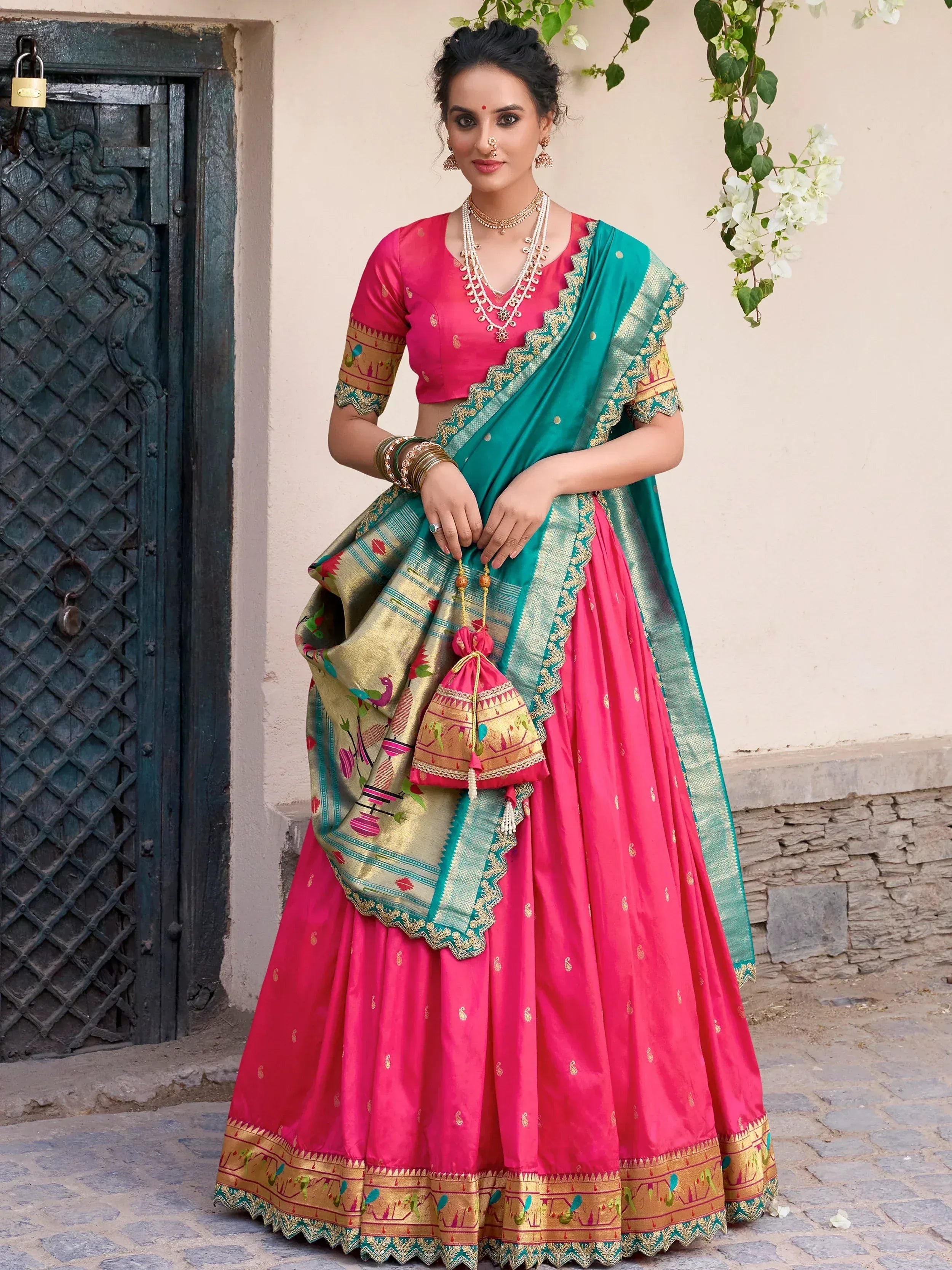 Pink and teal designer lehenga choli with intricate embroidery and gold detailing
