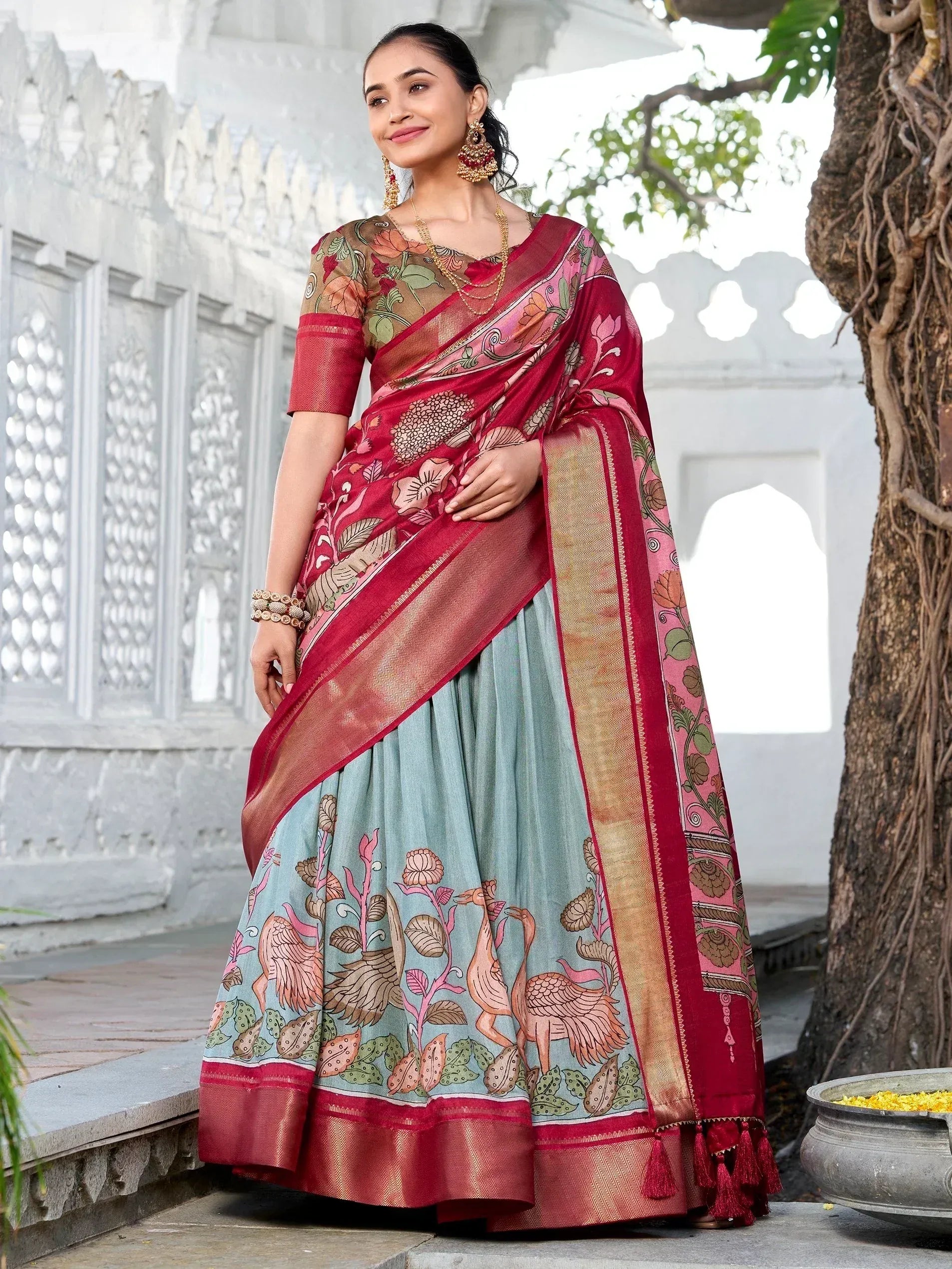 Woman in red and mint green printed saree with floral and bird motifs, traditional Indian ethnic wear