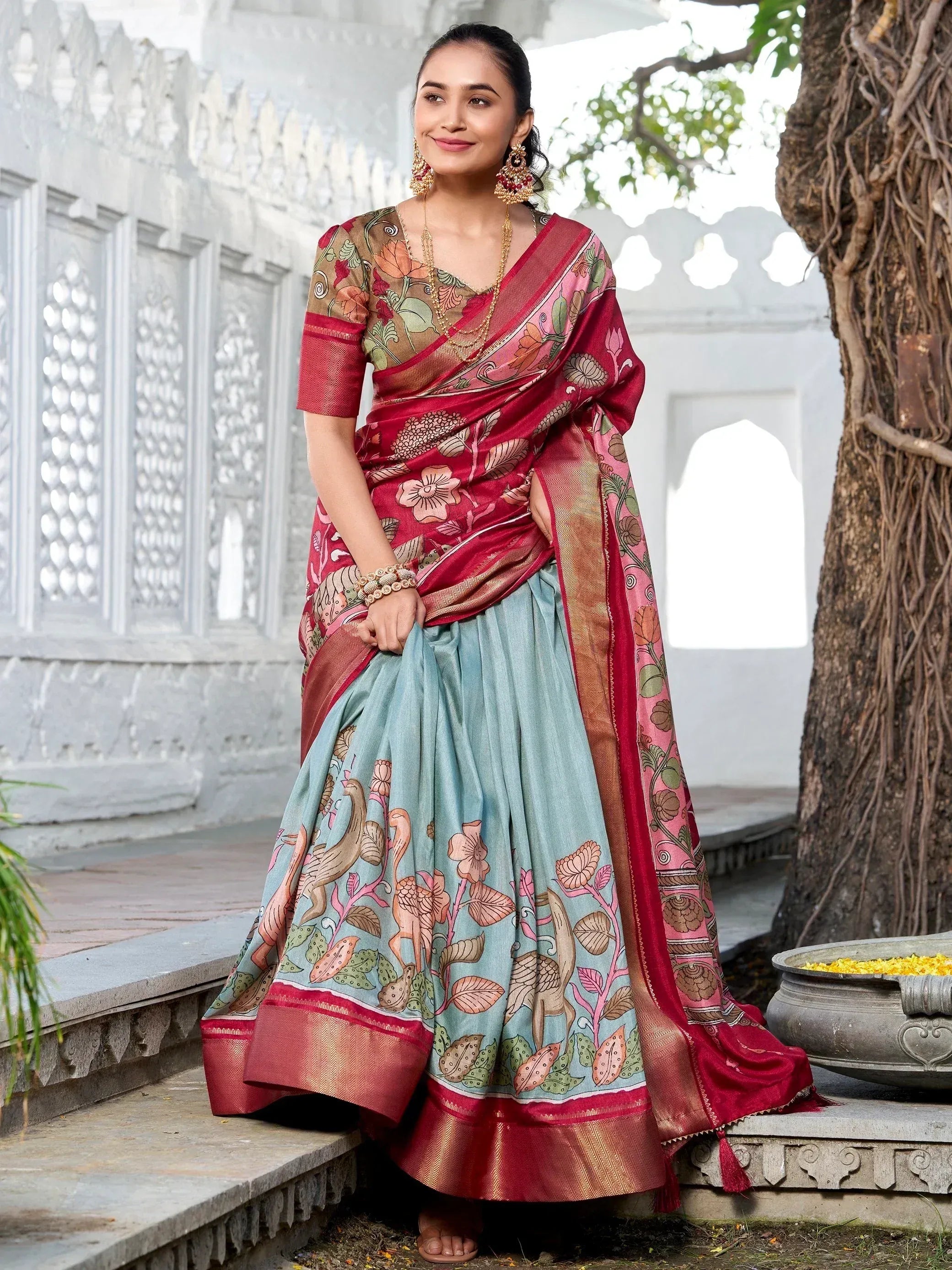 Woman in floral printed ethnic saree with red border, styled with traditional jewelry, perfect for Indian occasions
