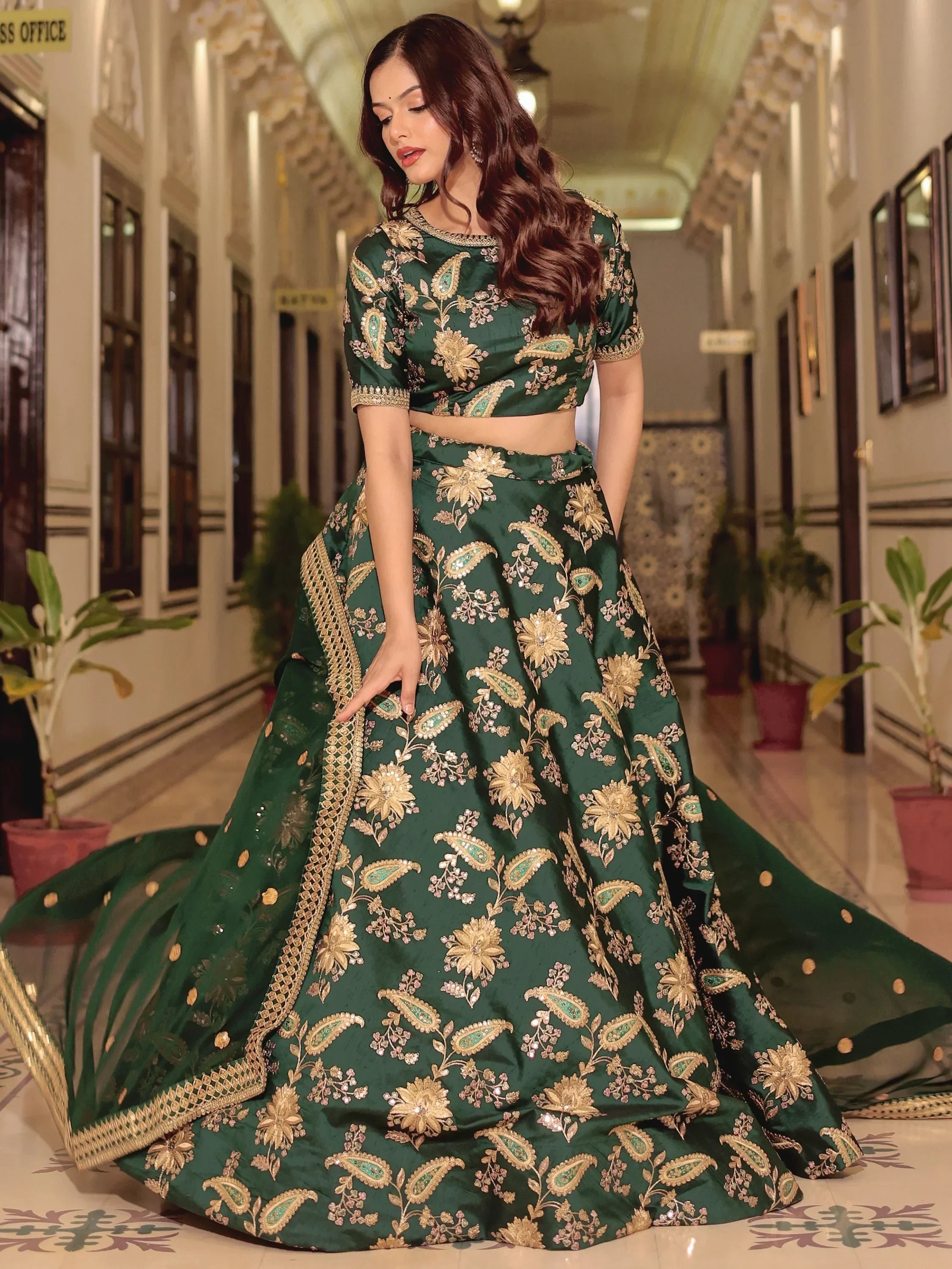 Emerald green designer lehenga choli with gold floral embroidery, perfect for weddings and festive occasions.