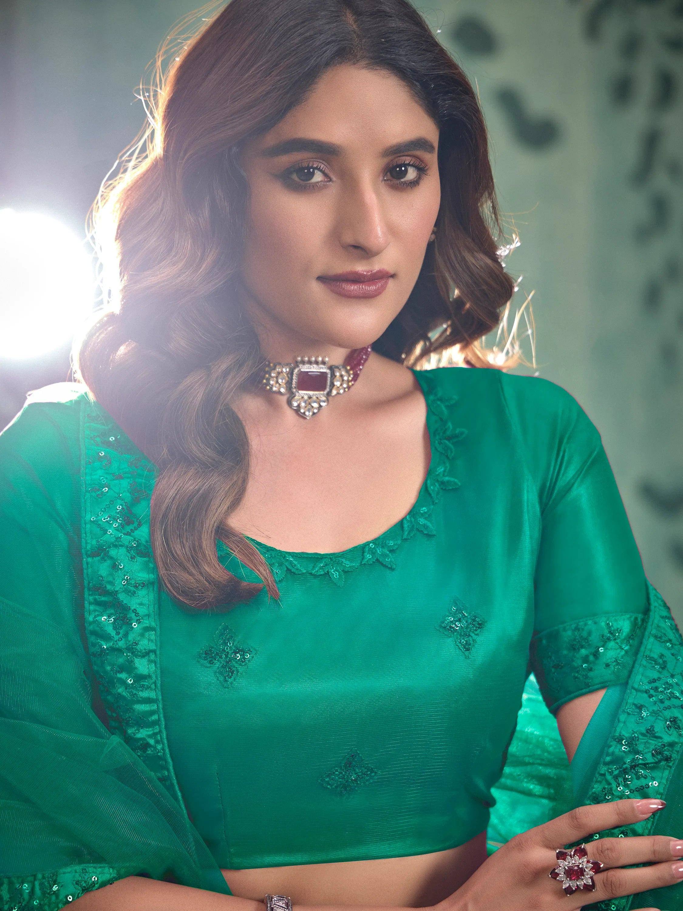 Emerald green designer blouse with sequin embroidery, paired with statement jewelry for Indian ethnic wear