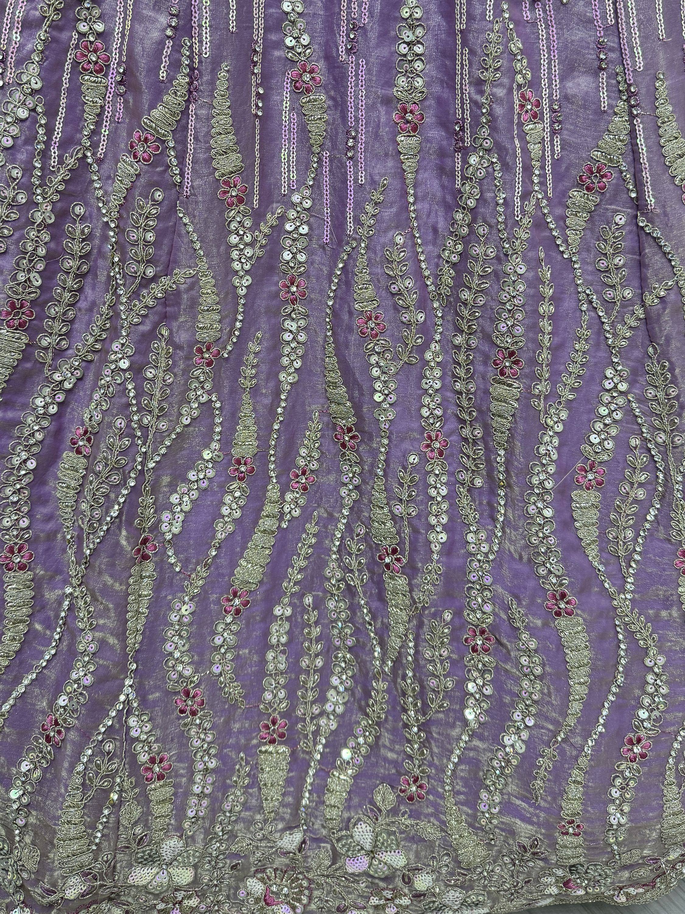 Purple ethnic gown with floral embroidery, sequins, and gold thread detailing for festive occasions.