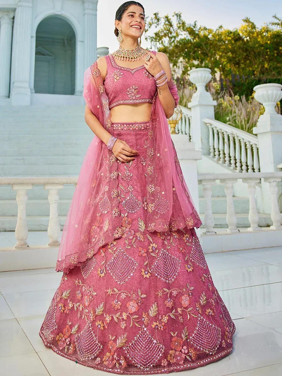 Pink embroidered lehenga choli with floral motifs, perfect for Indian weddings and festive occasions