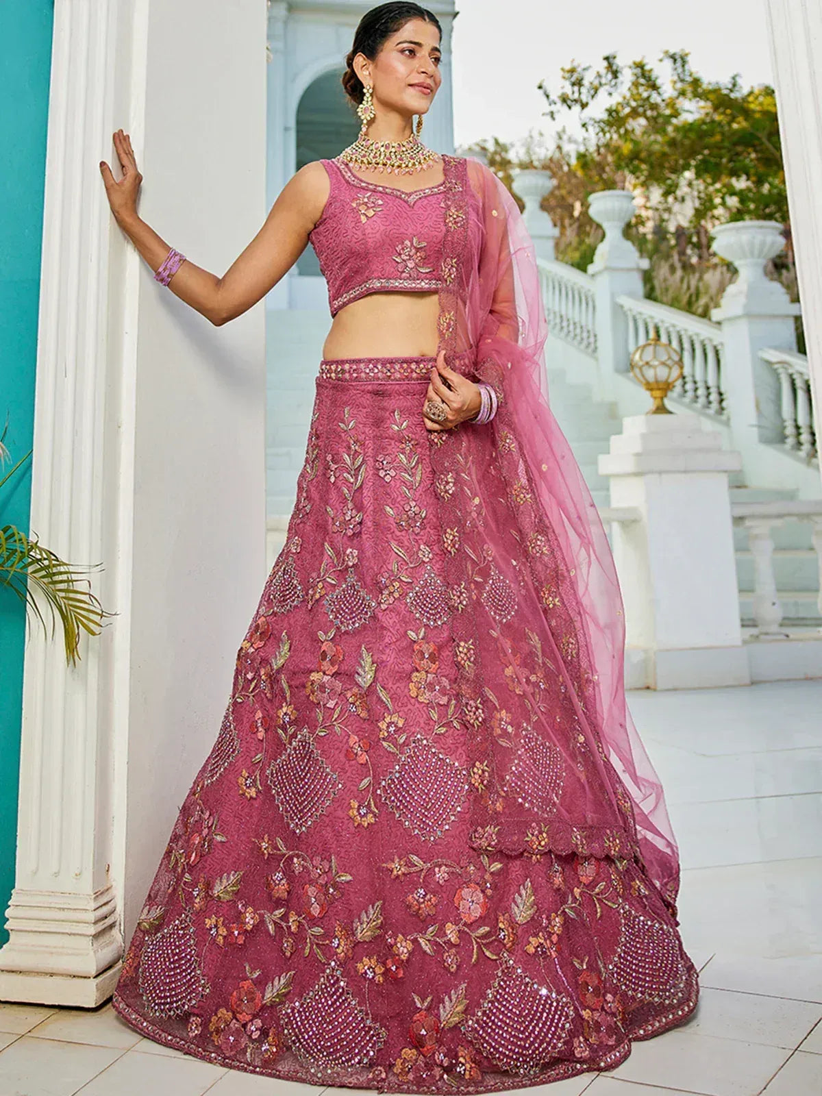 Pink embroidered lehenga choli with floral motifs and sheer dupatta, perfect for Indian weddings and festive occasions.