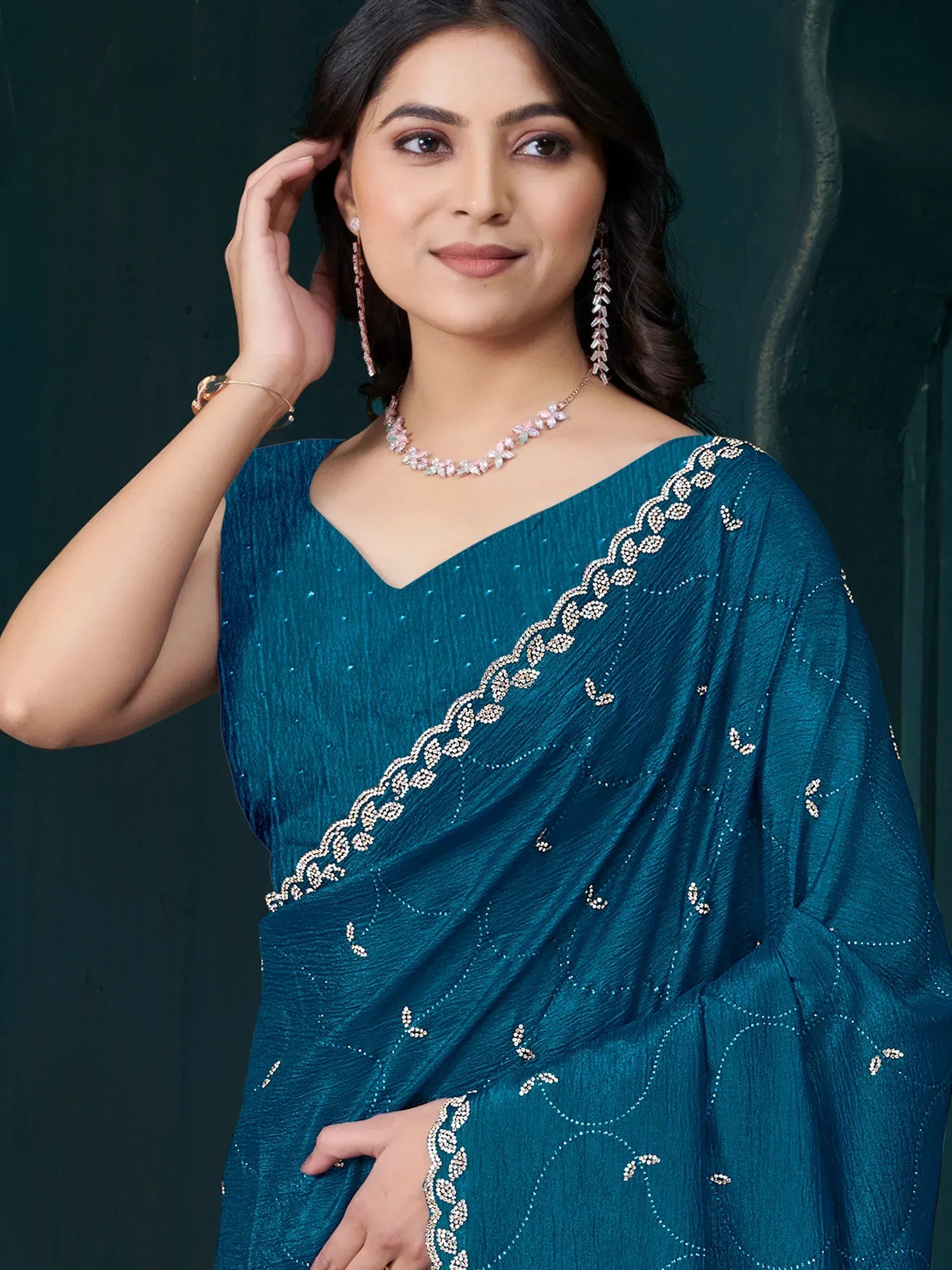 Teal embroidered saree with floral embellishments, perfect for Indian ethnic wear occasions.