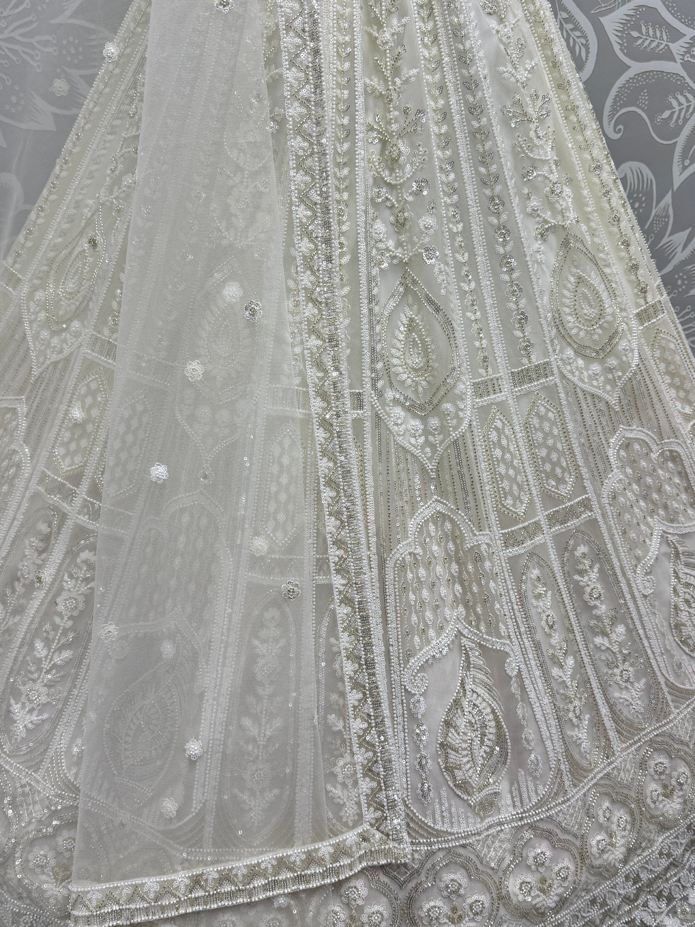 Elegant white ethnic gown with intricate beadwork and sequin embroidery, perfect for Indian weddings or festive occasions.