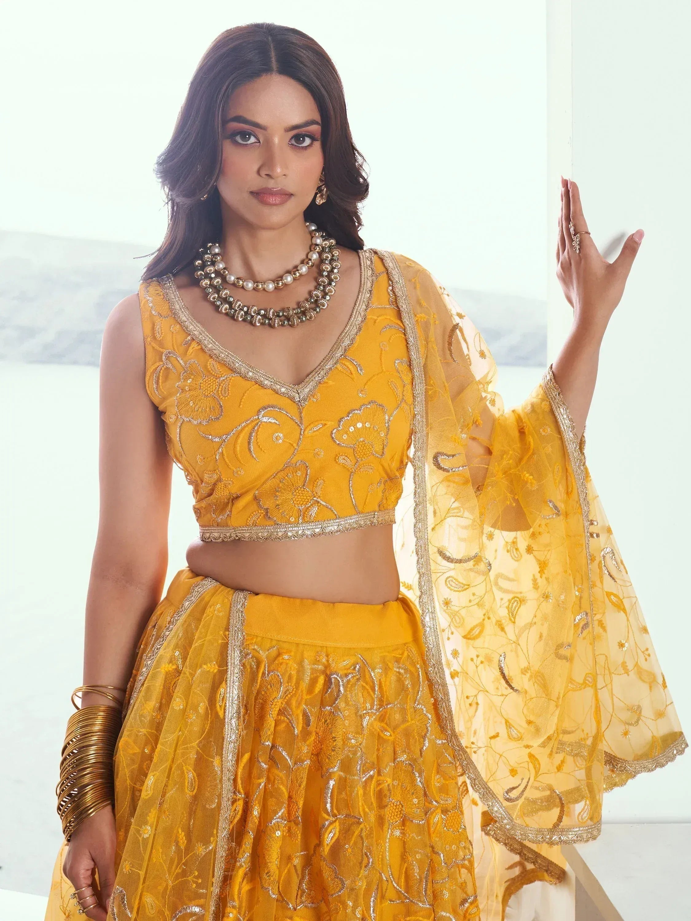 Yellow embroidered lehenga choli with gold detailing, perfect for Indian ethnic wear and festive occasions.