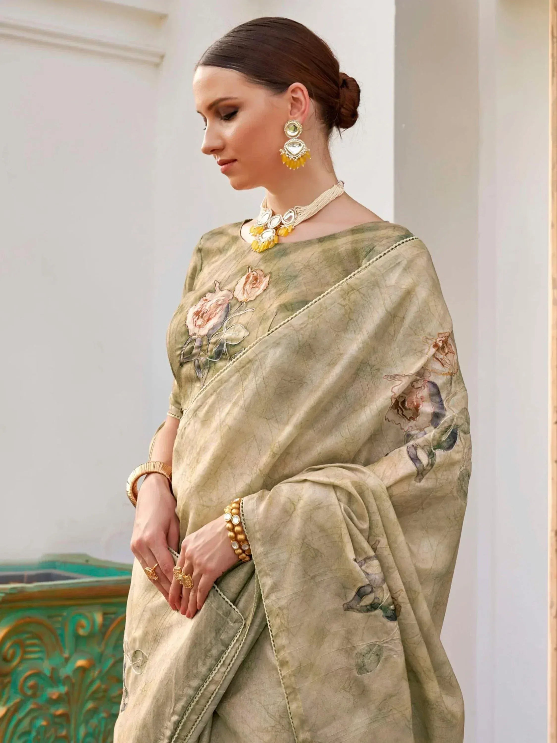 Elegant olive green saree with floral embroidery, paired with traditional Indian jewelry for festive occasions.