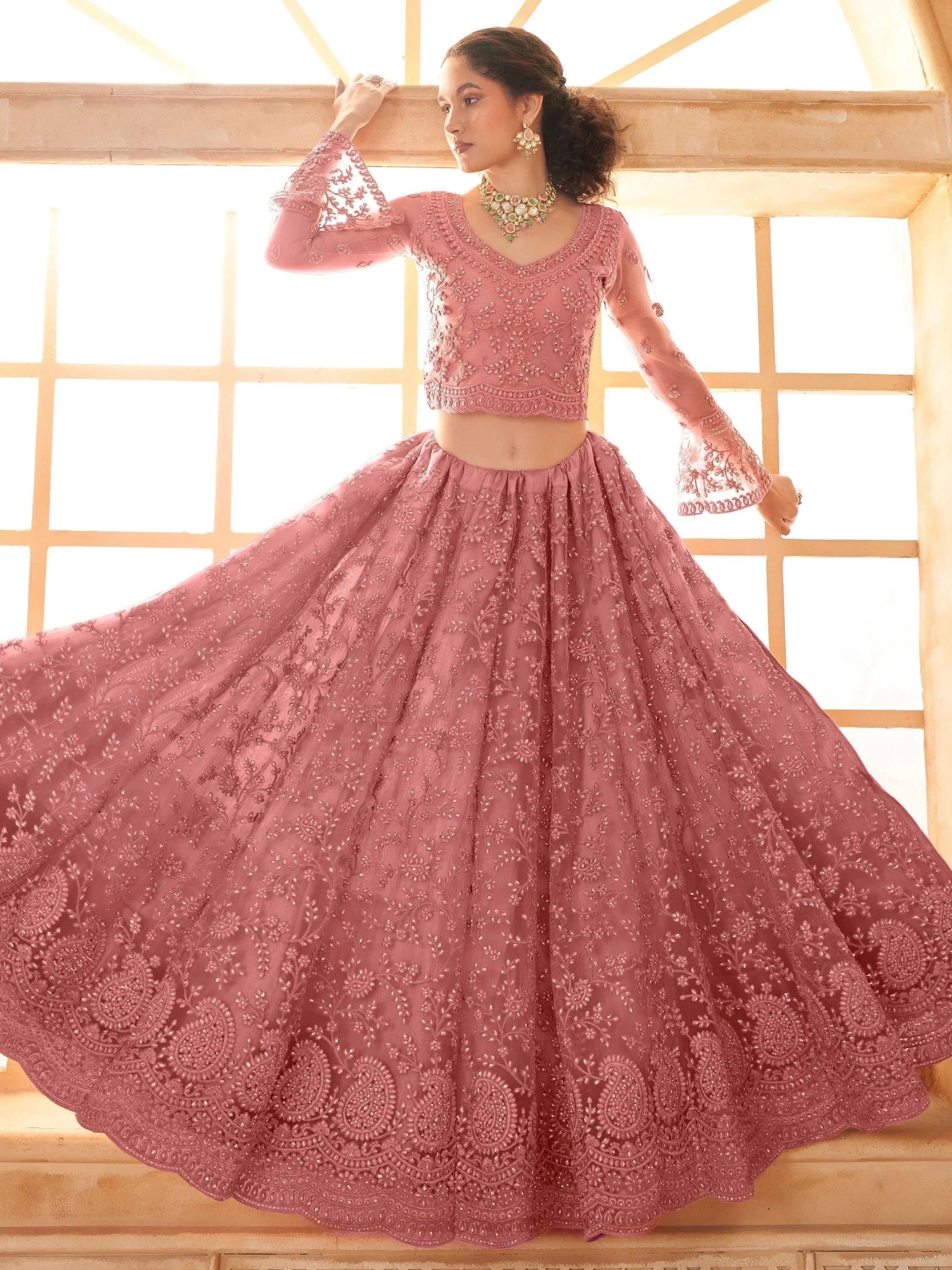 Pink embroidered lehenga choli with flared skirt and bell sleeves, perfect for Indian ethnic wear occasions