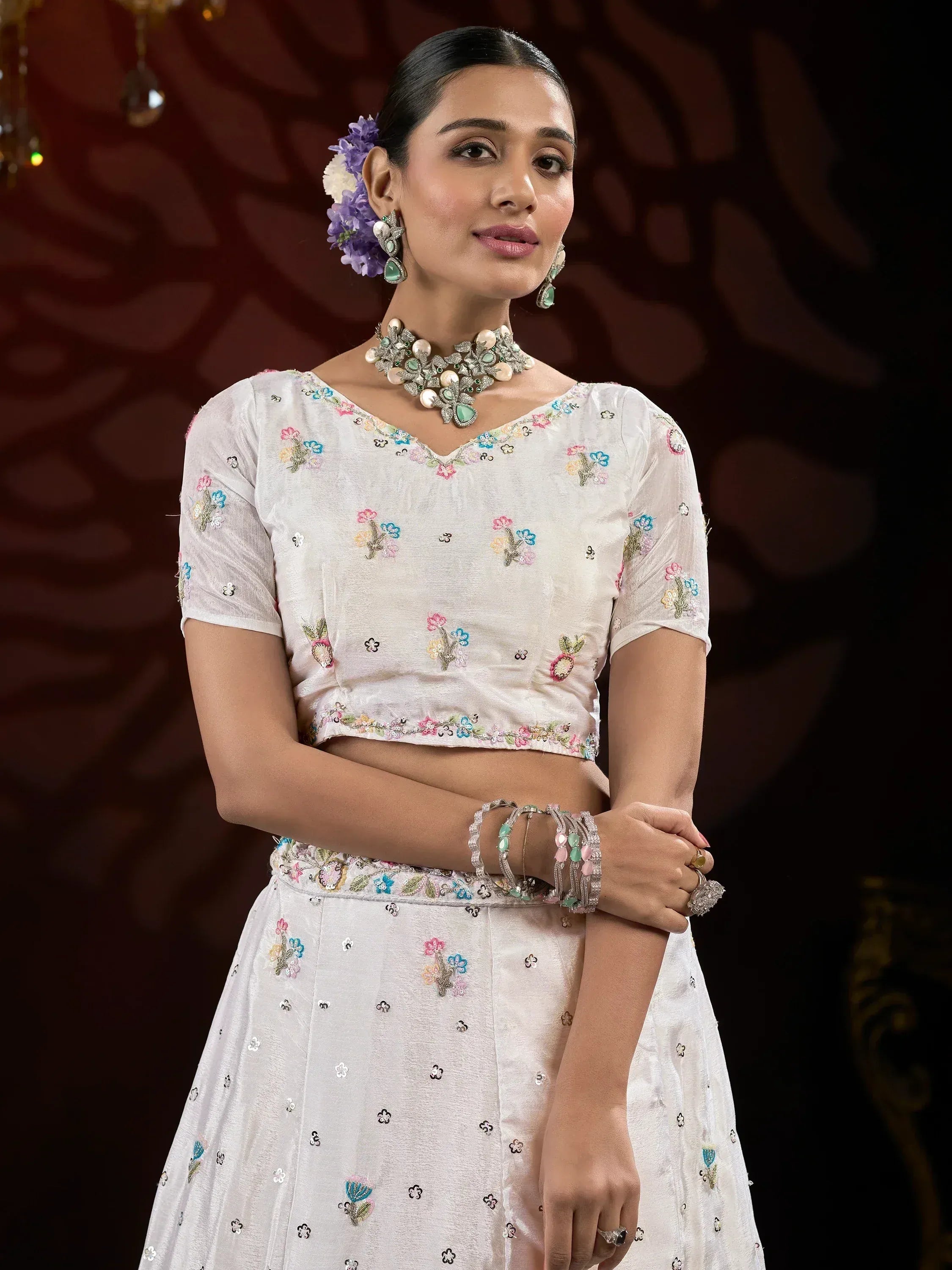 White floral embroidered lehenga choli with matching jewelry for Indian ethnic wear