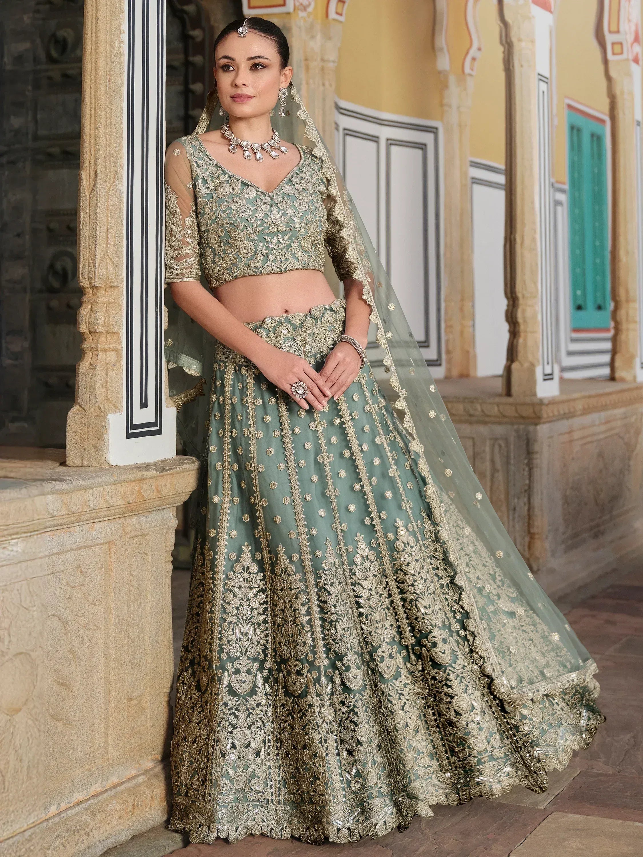 Elegant sage green lehenga choli with gold embroidery, perfect for Indian weddings and festive occasions.