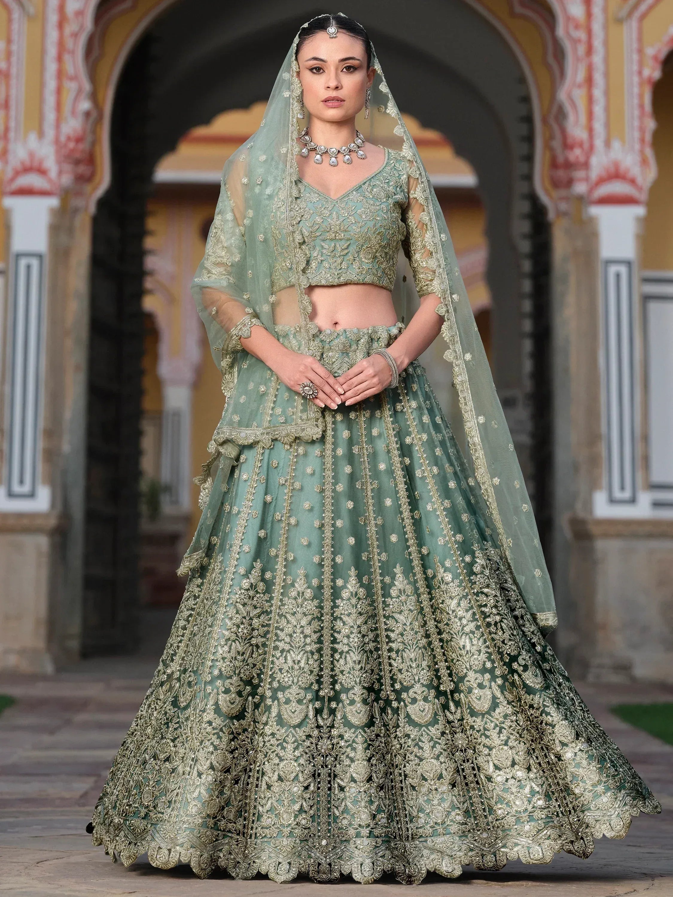 Mint green designer lehenga choli with gold embroidery, perfect for Indian weddings and festive occasions.