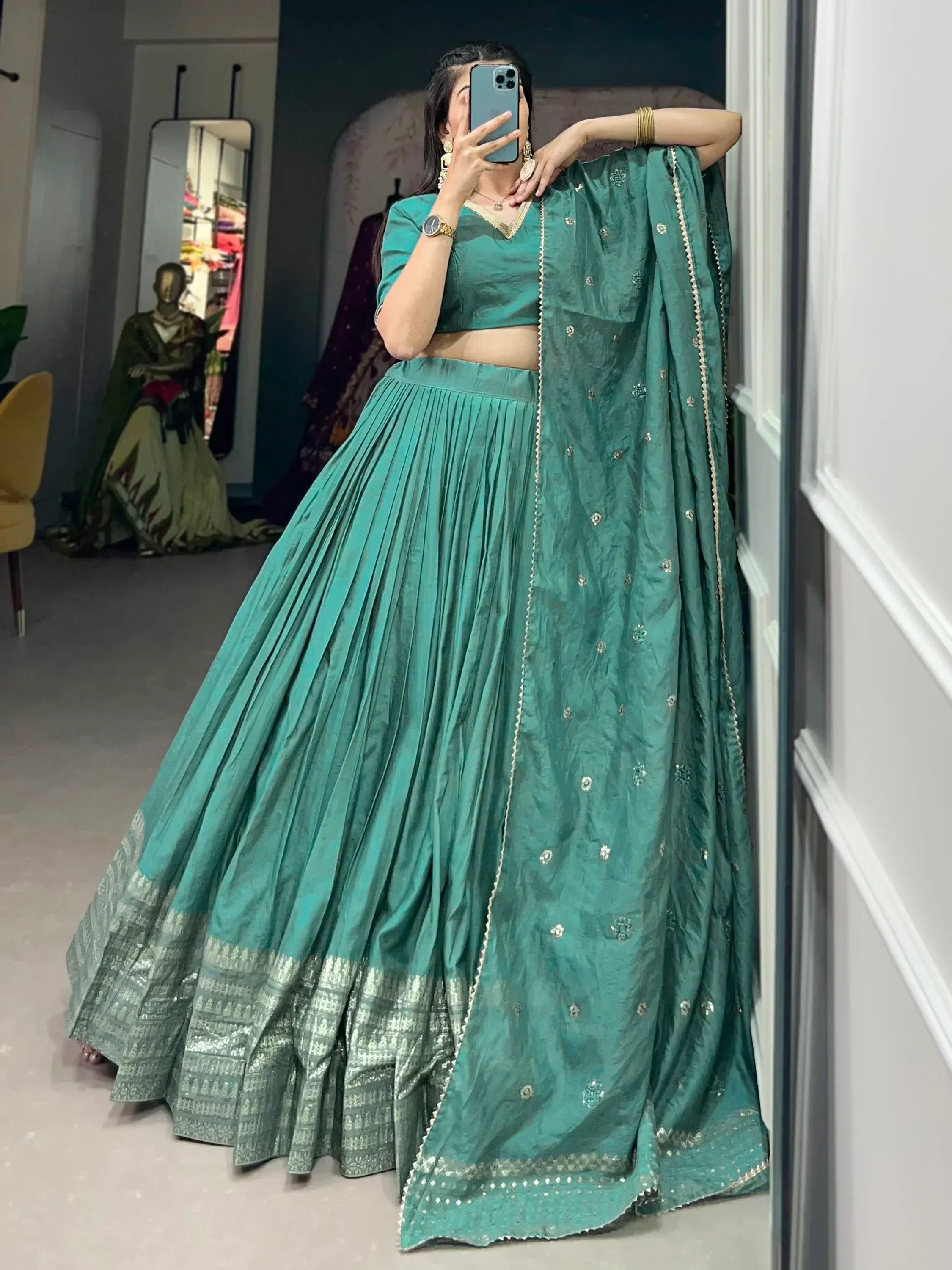 Teal green designer lehenga choli with gold embroidery and pleated skirt, perfect for Indian ethnic wear occasions