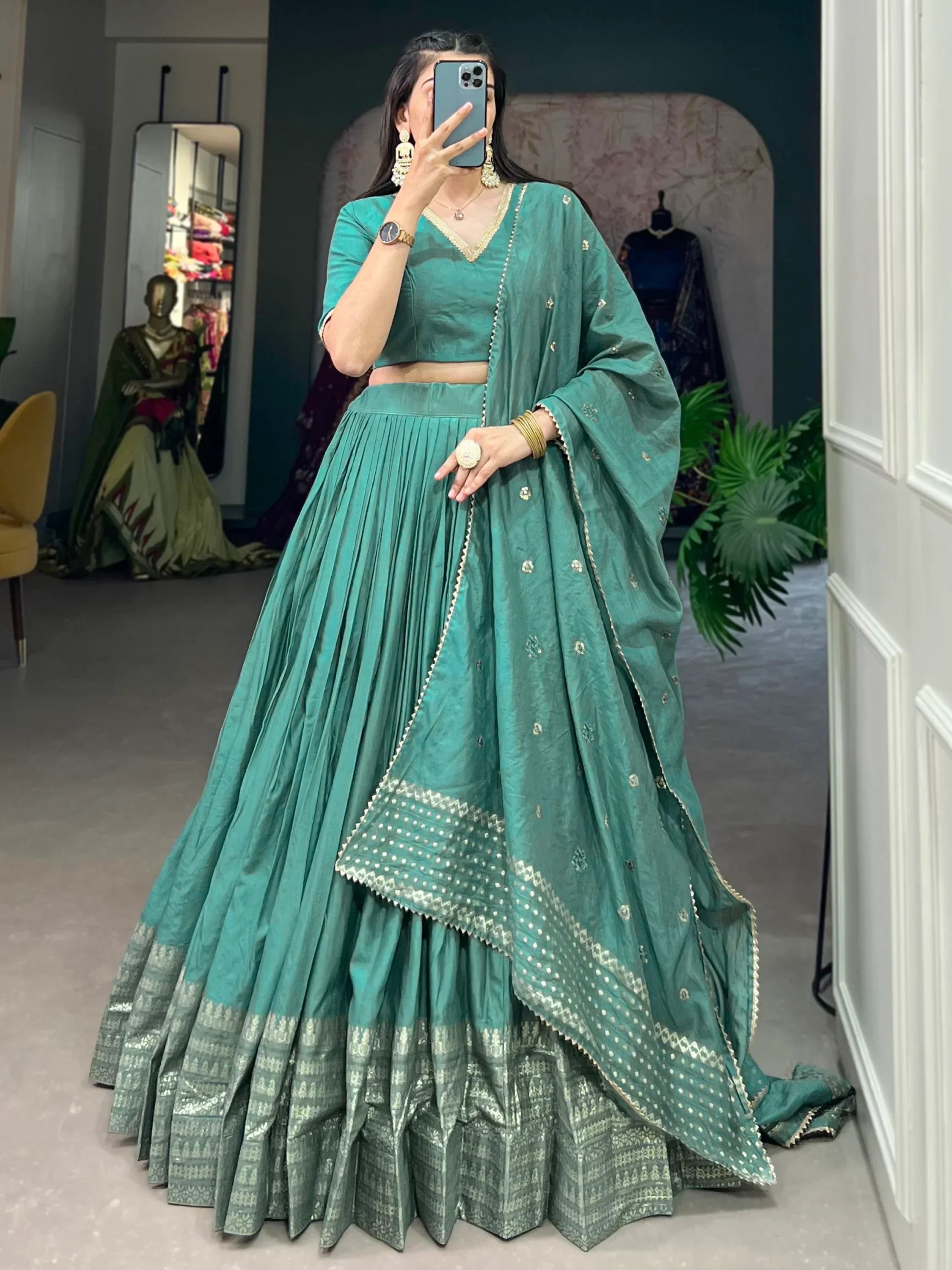 Teal green lehenga choli with gold embroidery, pleated skirt, and matching dupatta for Indian ethnic wear