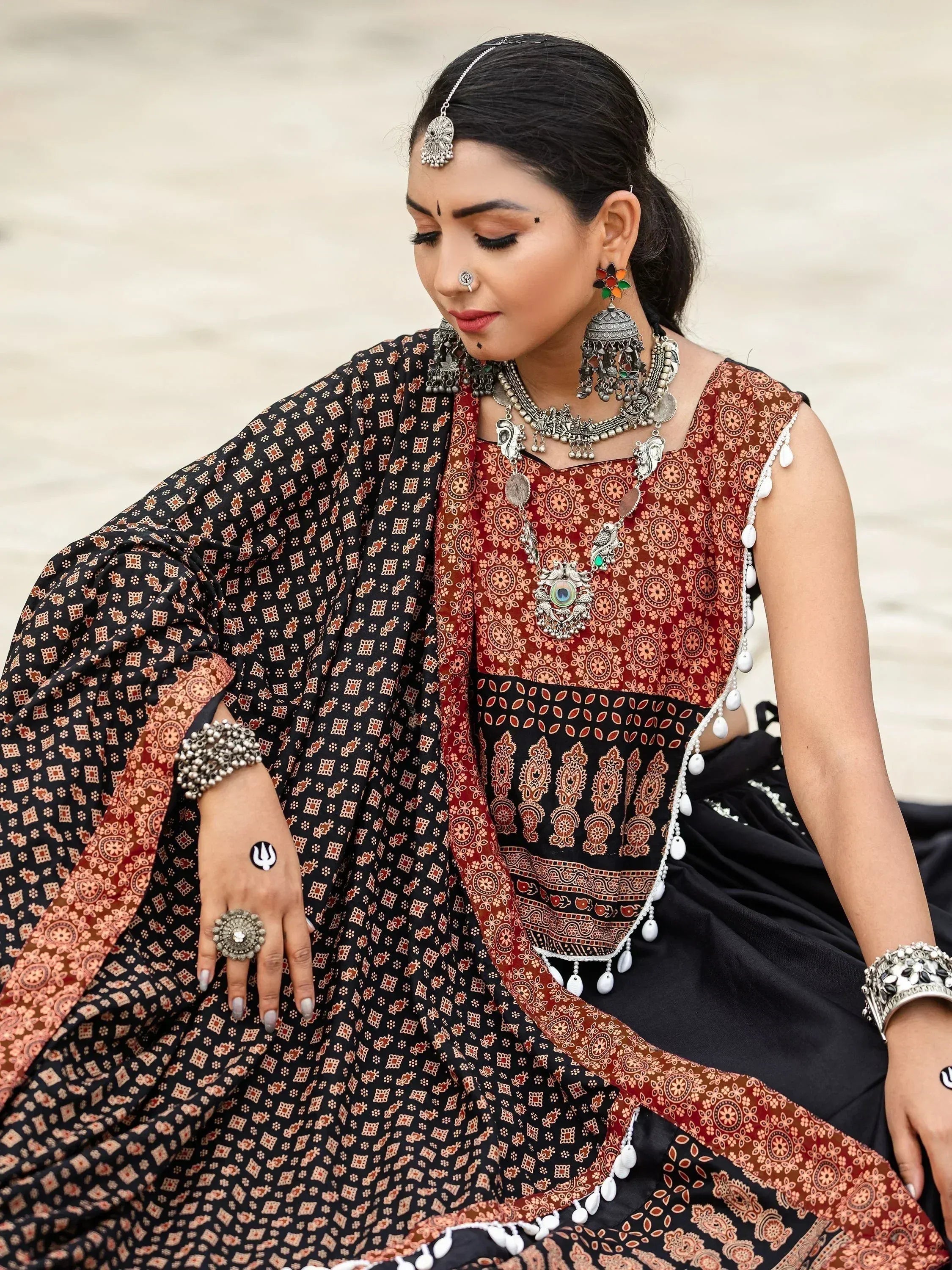 Woman in traditional Indian ethnic wear with intricate patterns, silver jewelry, and nose ring