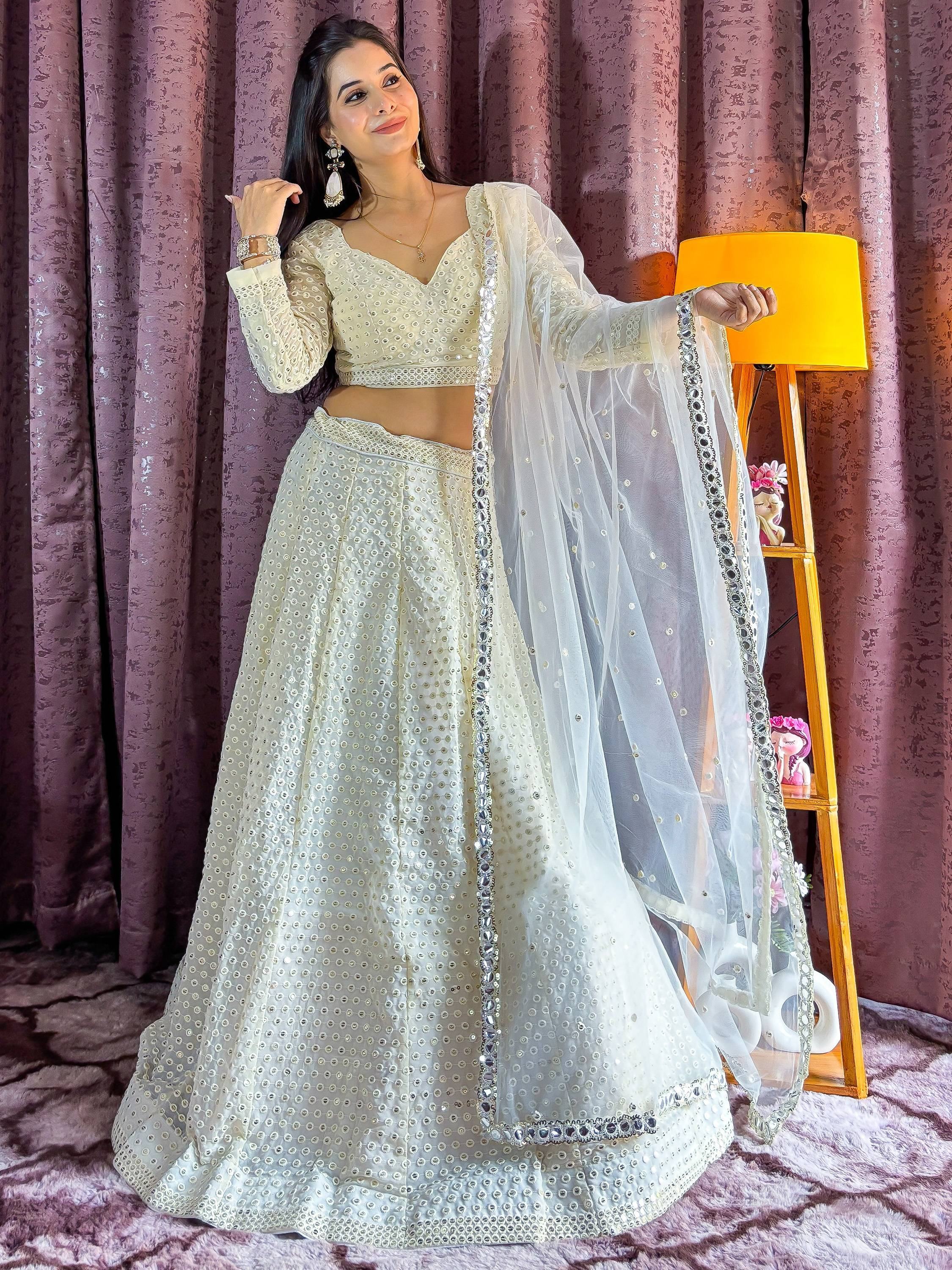 Elegant white mirror work lehenga choli with sheer dupatta, perfect for Indian ethnic wear and festive occasions.