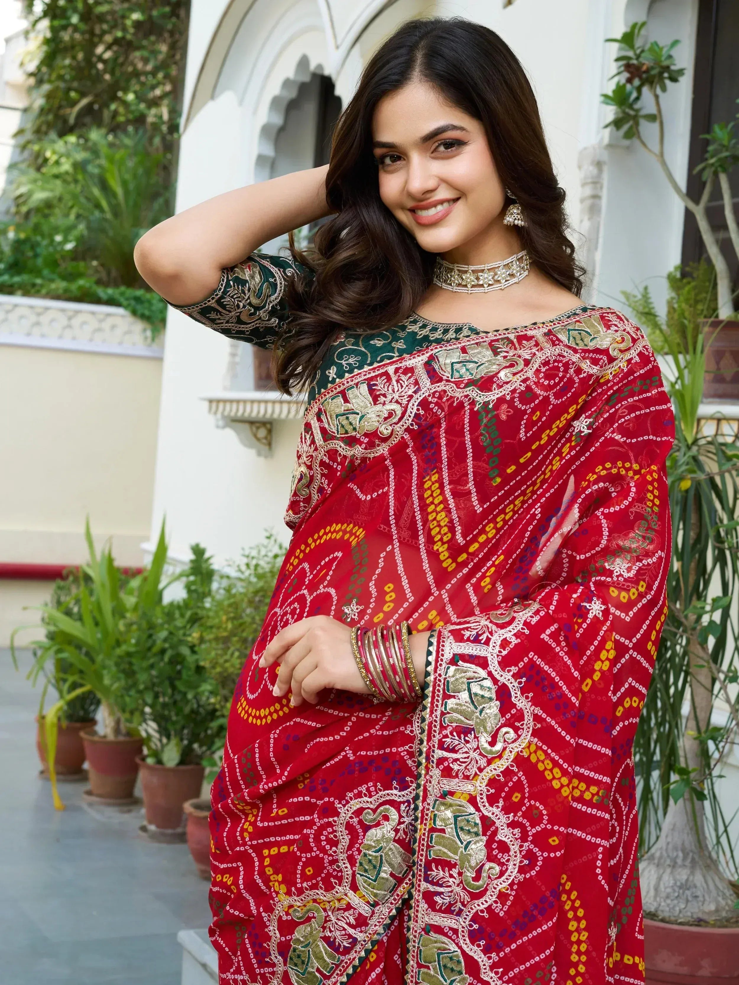 Woman in red embroidered saree with elephant motifs, traditional Indian ethnic wear