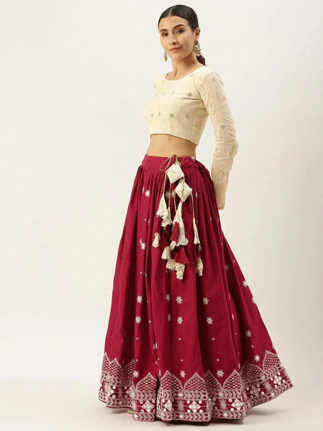 Maroon embroidered lehenga with cream crop top, tassel details, and ethnic print for Indian festive wear
