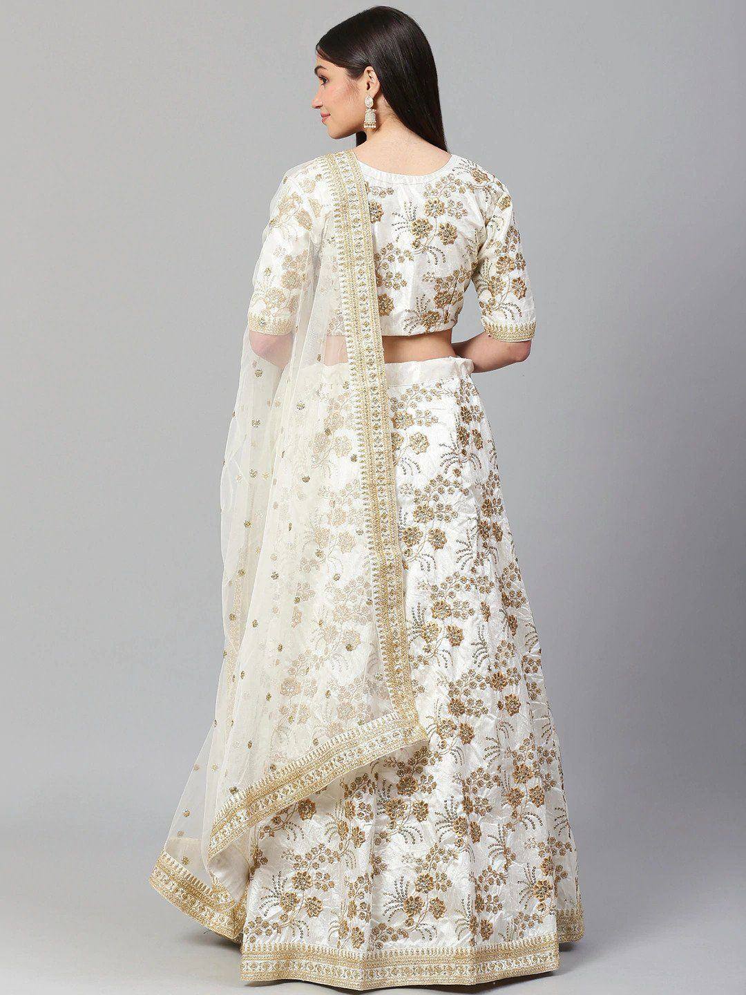White and gold embroidered lehenga choli with floral motifs and sheer dupatta, perfect for Indian weddings or festive occasions.