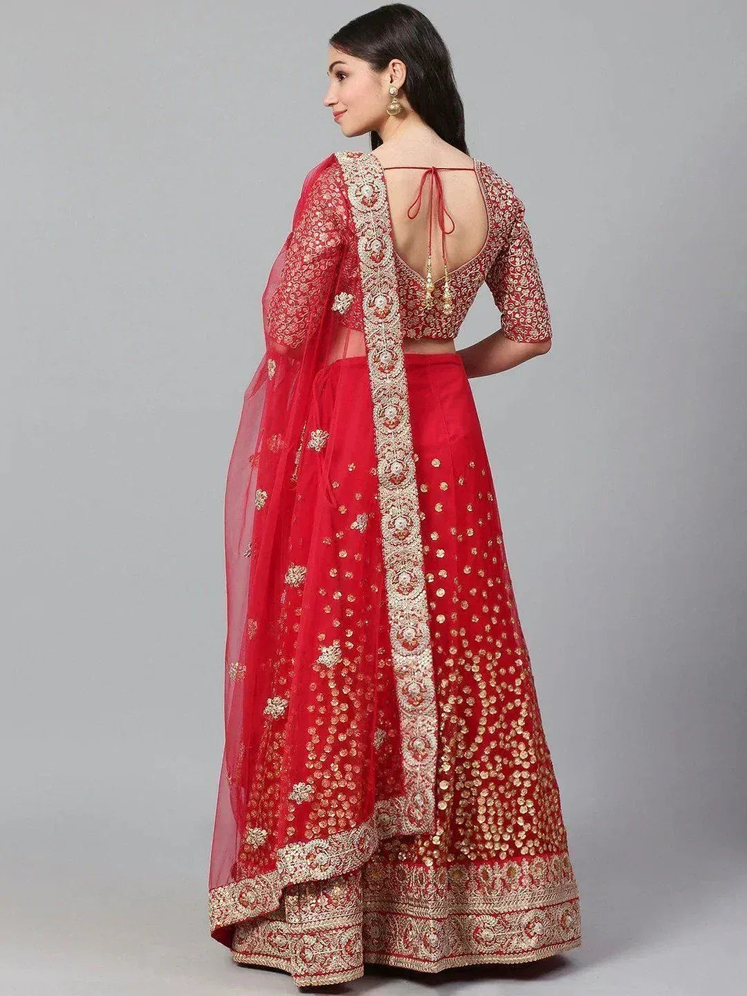 Red embroidered lehenga choli with gold detailing and sheer dupatta, perfect for Indian weddings and festive occasions