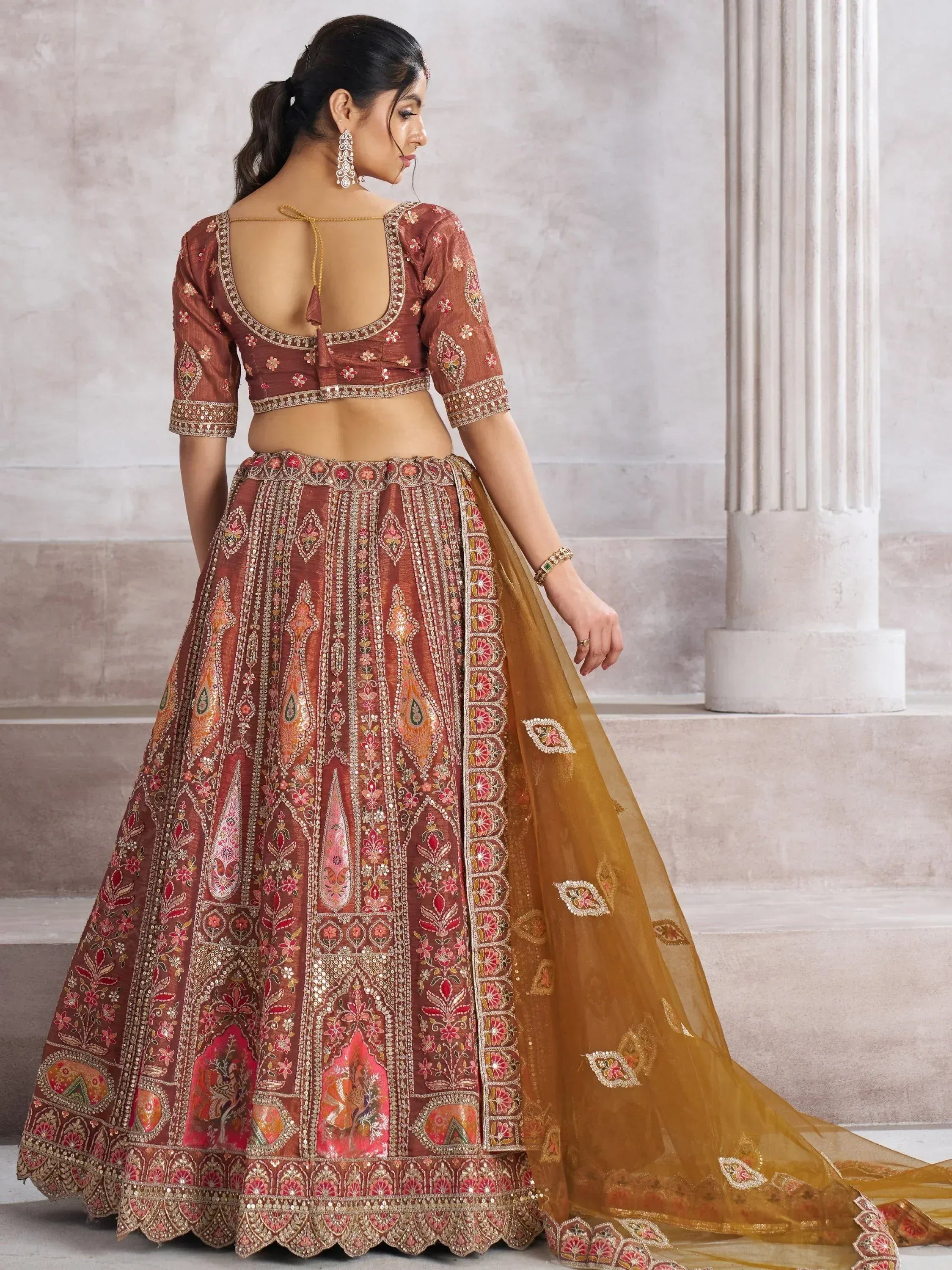 Elegant maroon lehenga choli with intricate floral embroidery and gold detailing, perfect for Indian weddings.
