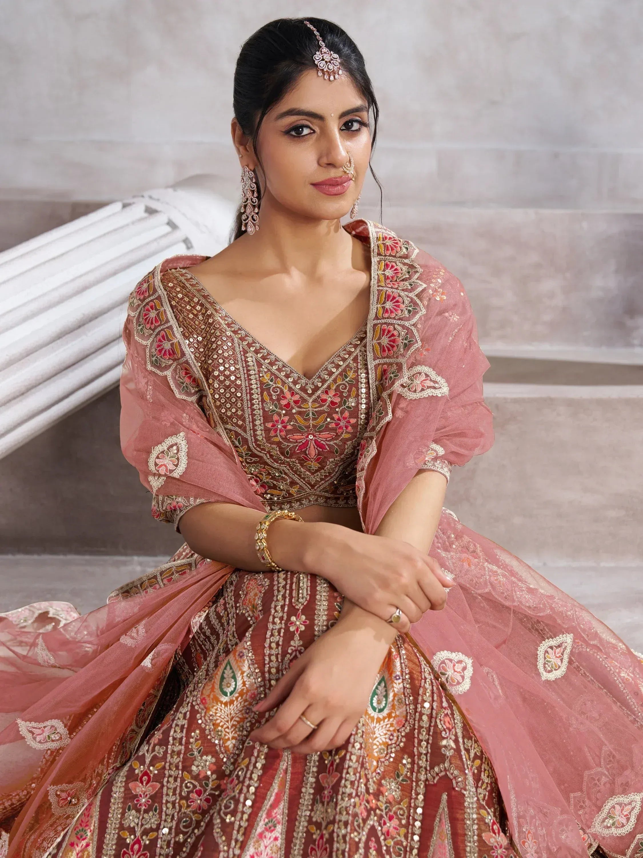 Elegant pink embroidered lehenga choli with floral motifs and sheer dupatta, perfect for Indian weddings and festive occasions.