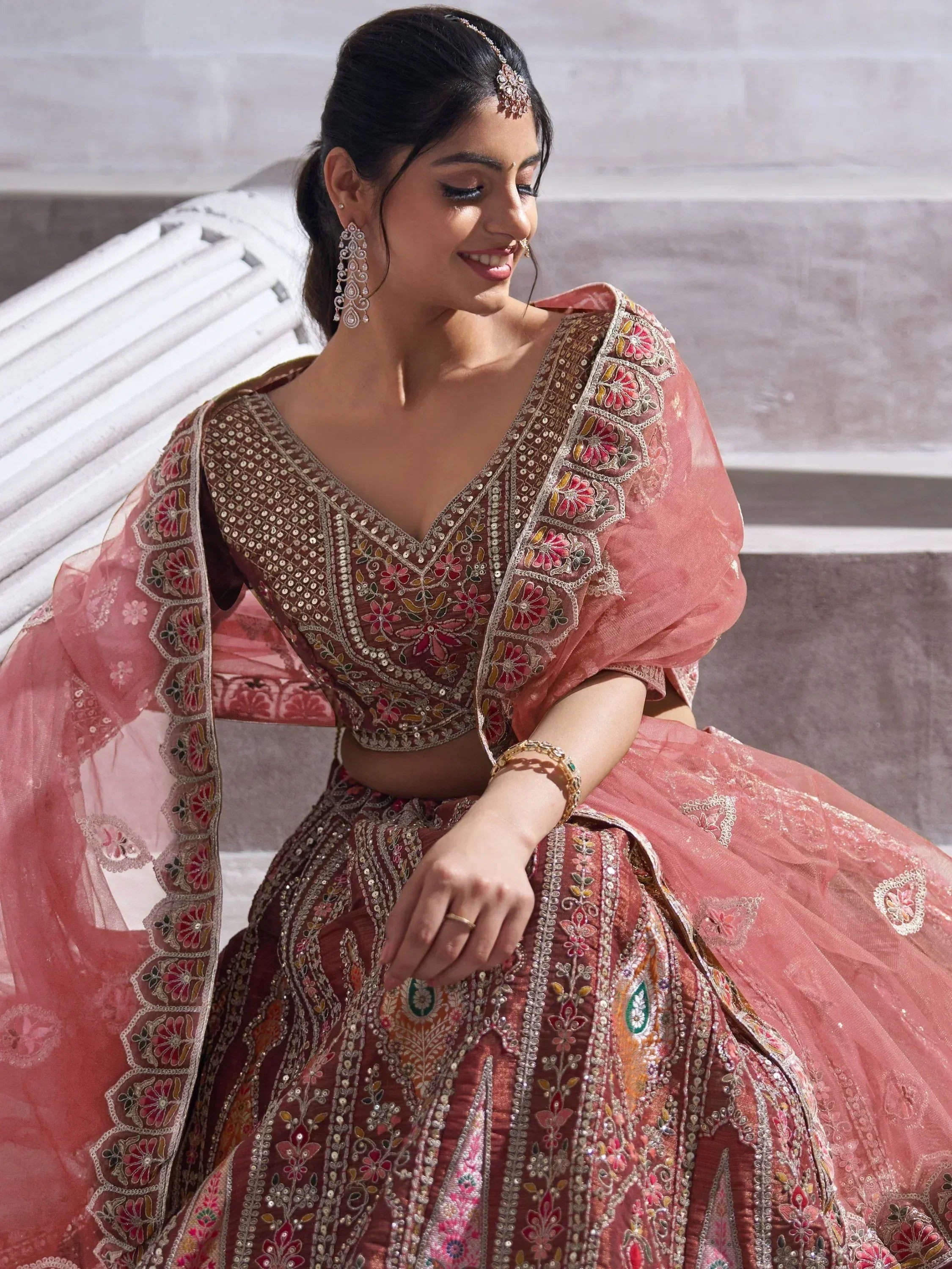 Elegant pink embroidered lehenga choli with floral motifs and sequin detailing, perfect for Indian weddings or festive occasions.