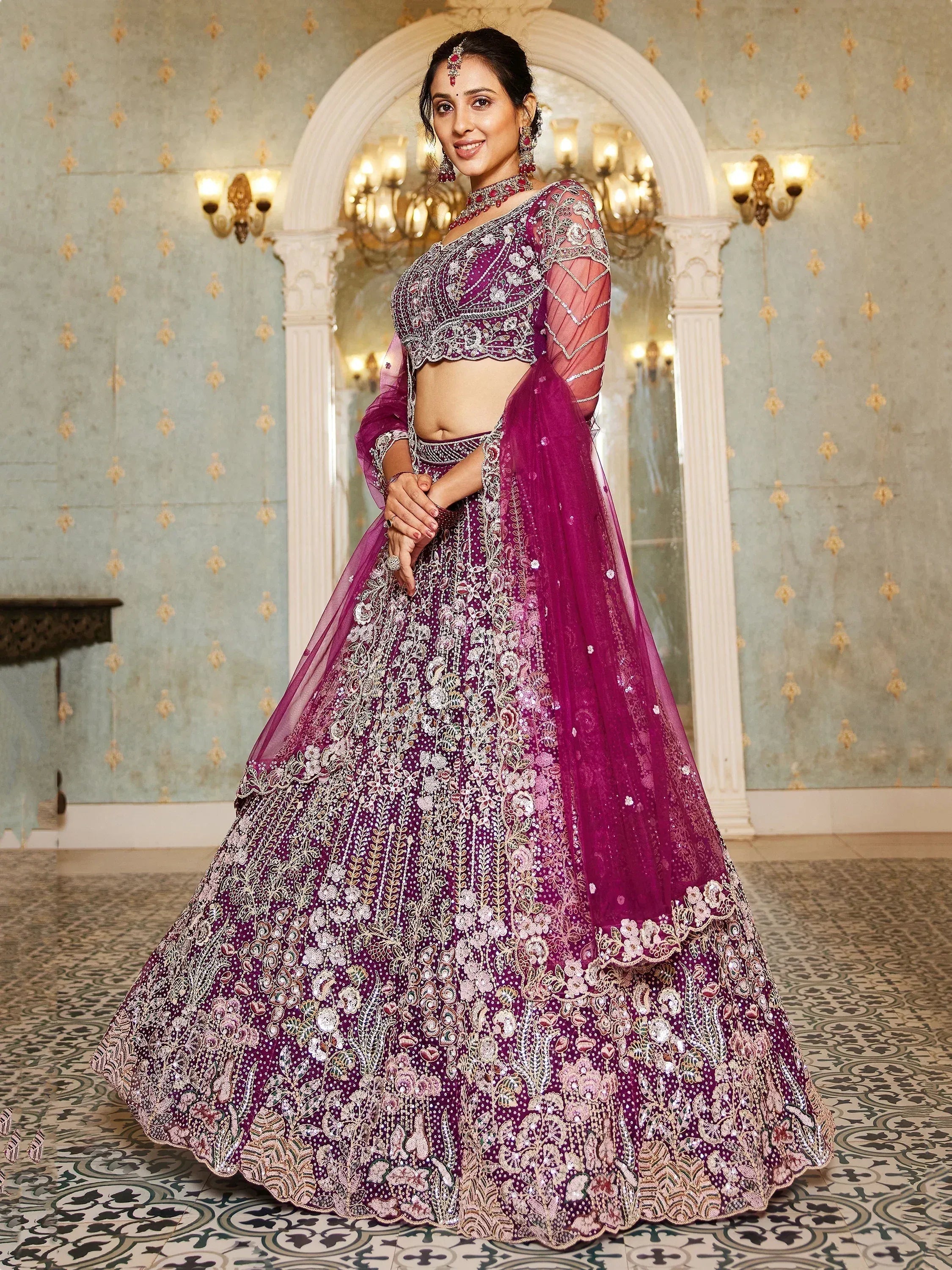 Elegant purple designer lehenga choli with intricate embroidery and sheer sleeves, perfect for Indian weddings.