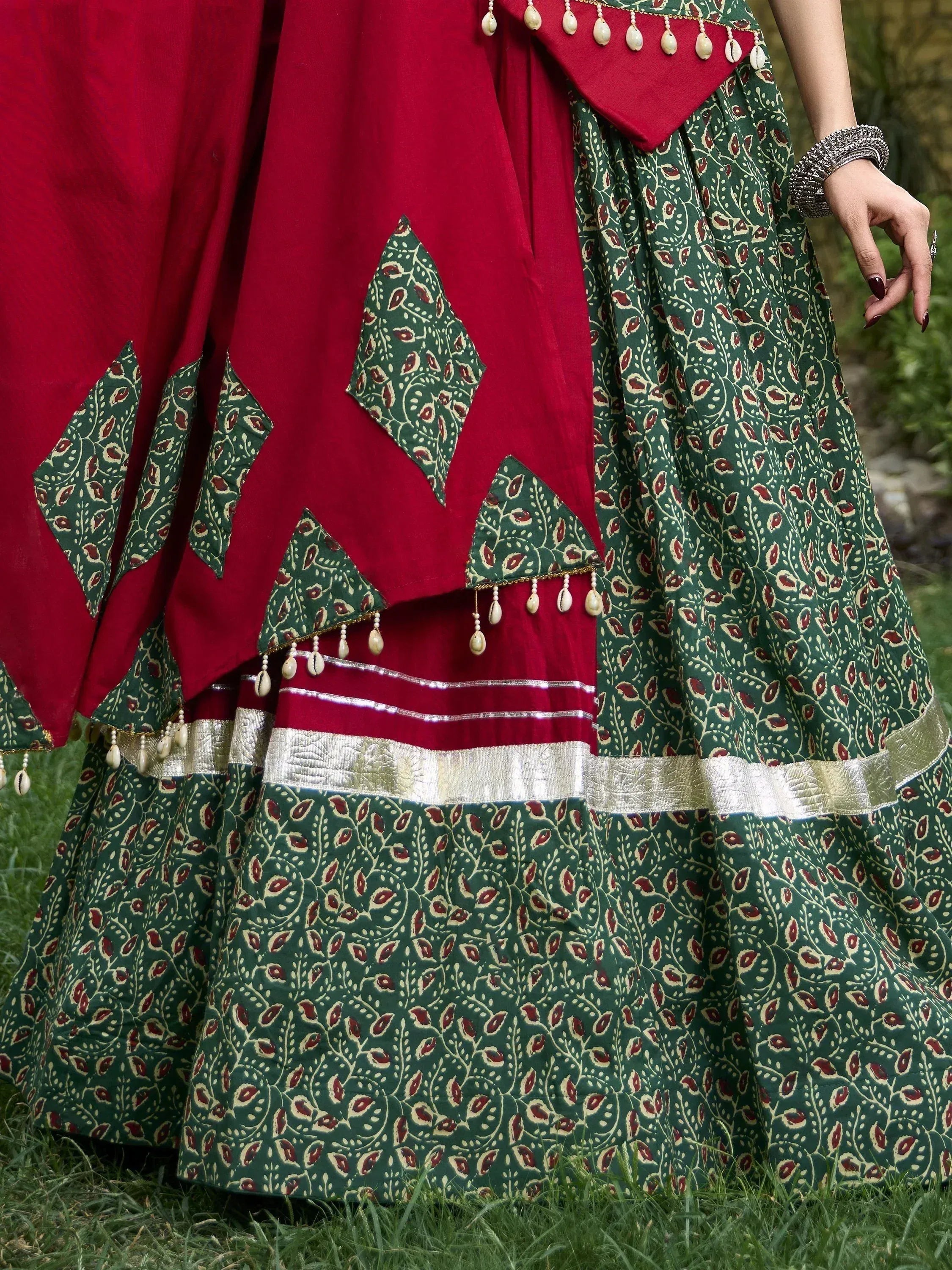 Red and green printed lehenga choli with shell tassels and gold border, ethnic Indian wear